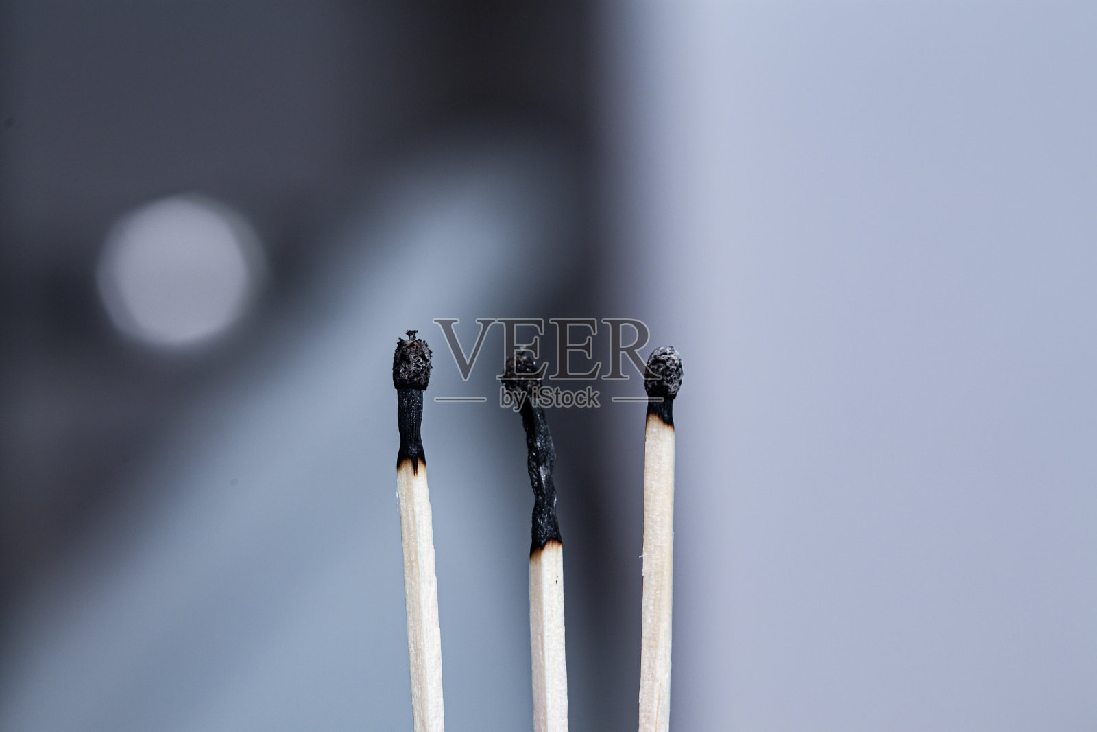 三根烧过的黑火柴棒排成一排，离得更近了照片摄影图片