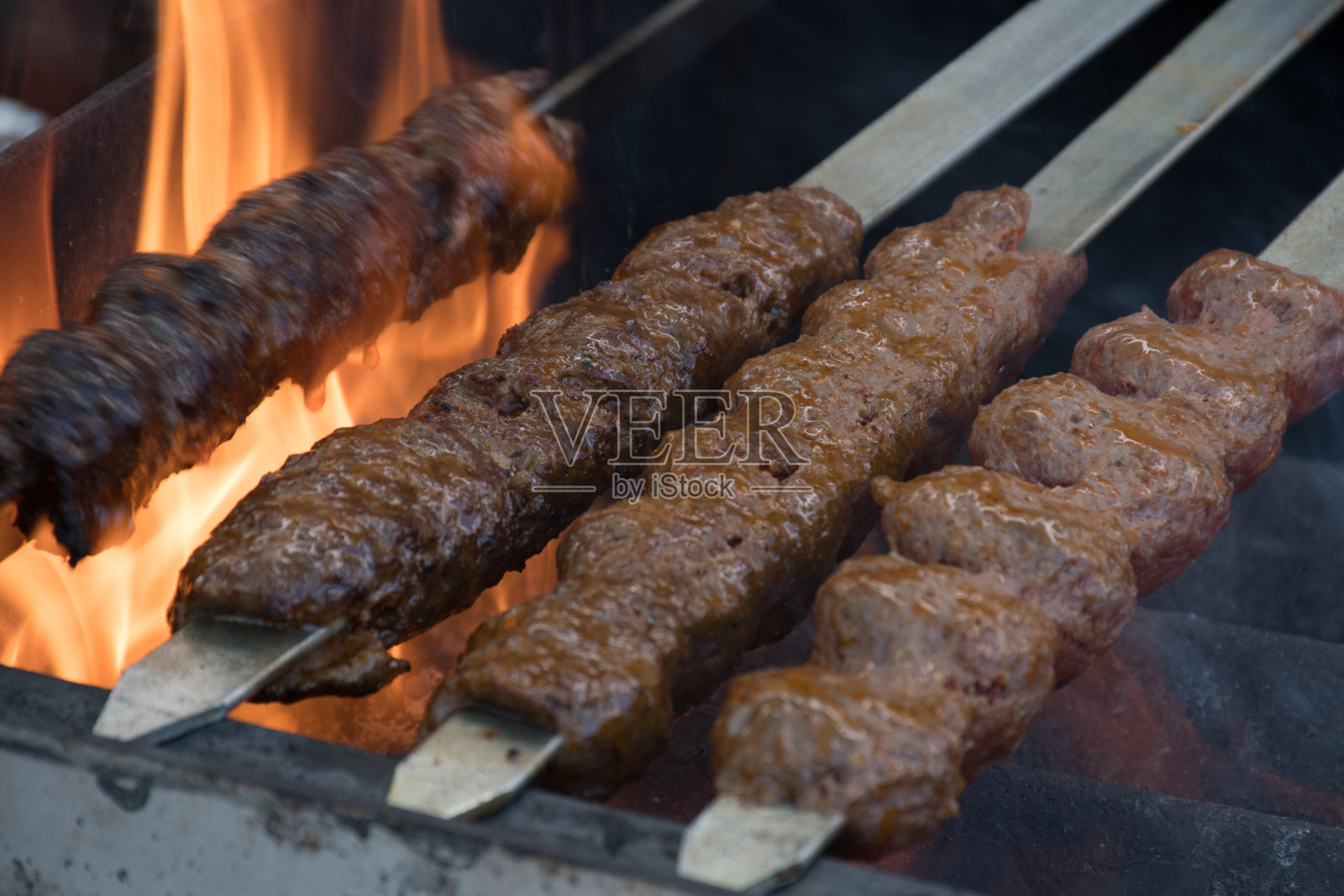 羊肉串(用炭串在烤架上的碎羊肉)。照片摄影图片