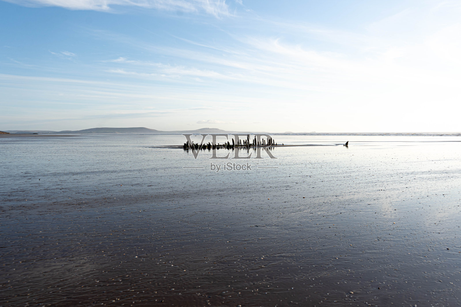 日落时在海滩上失事的船照片摄影图片
