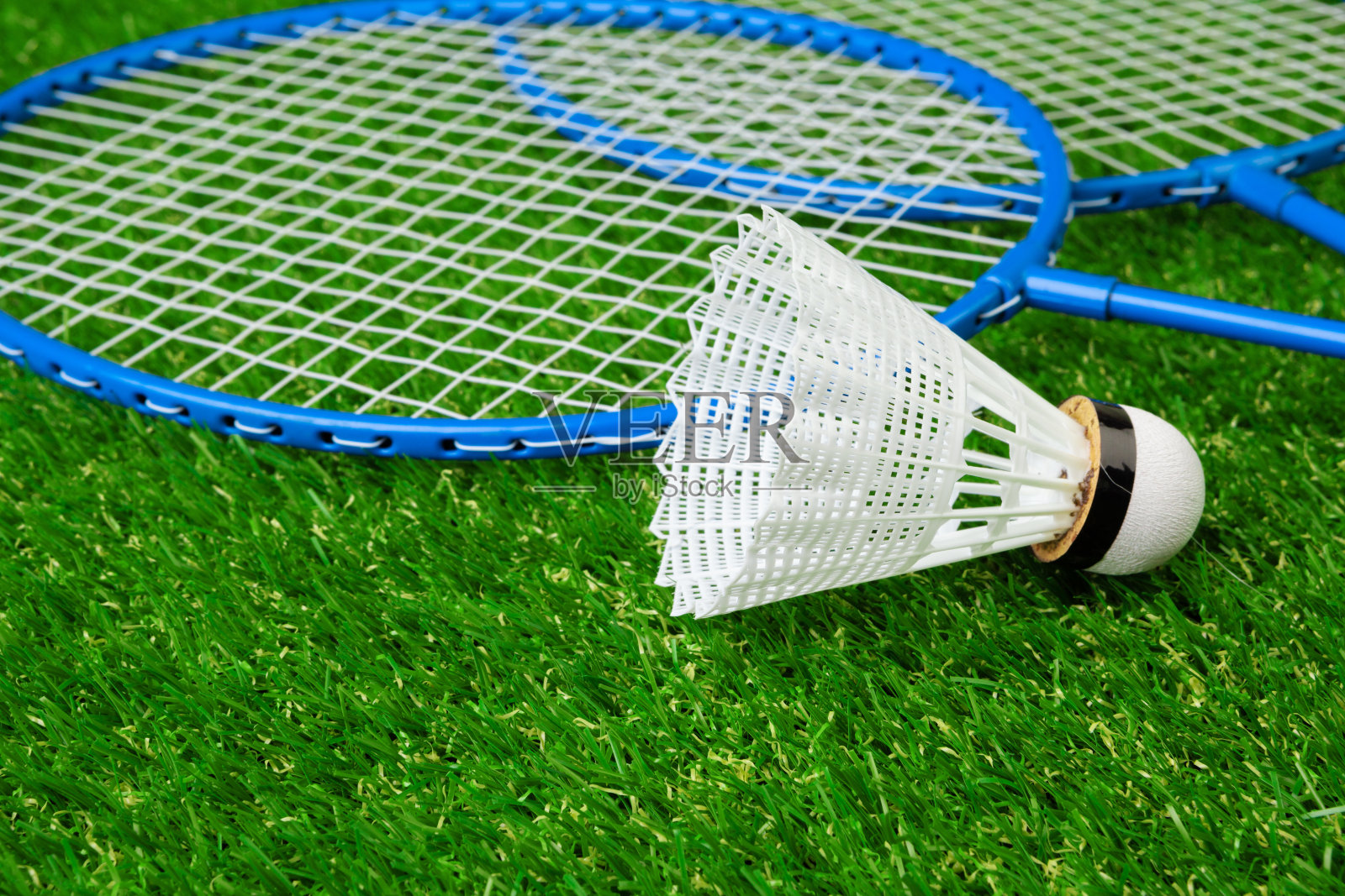 羽毛球游戏的拍子和羽毛球在草地上照片摄影图片