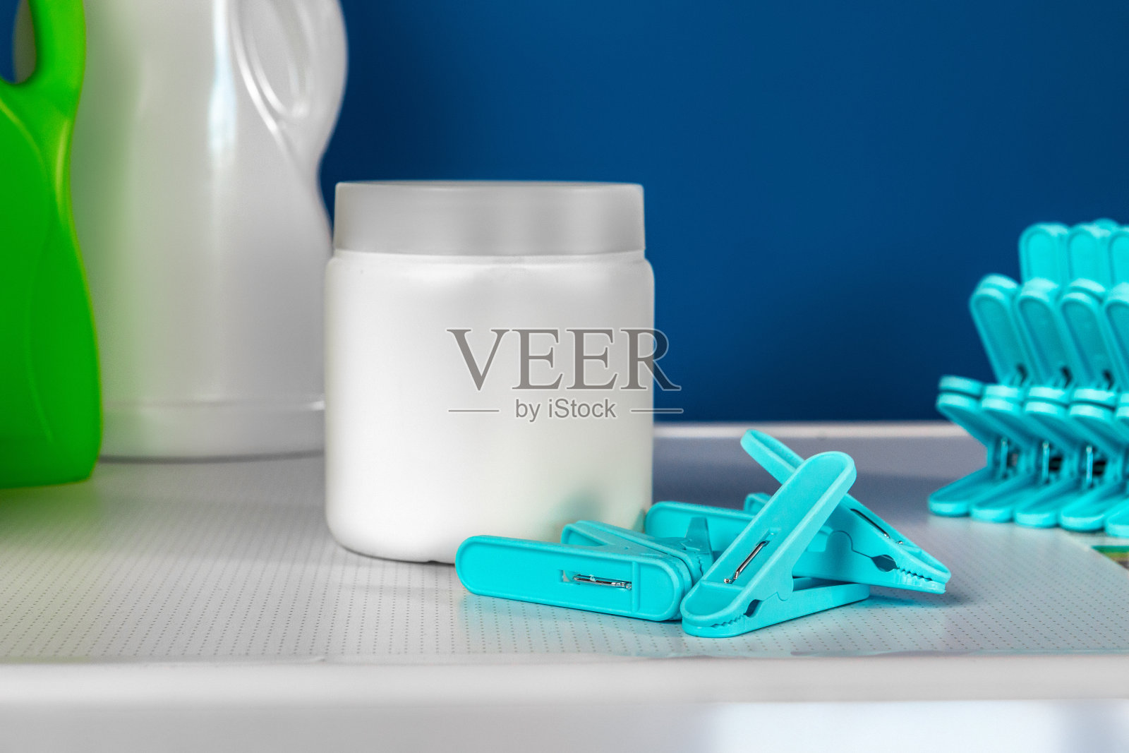 白色洗衣机上的蓝色衣服别针照片摄影图片