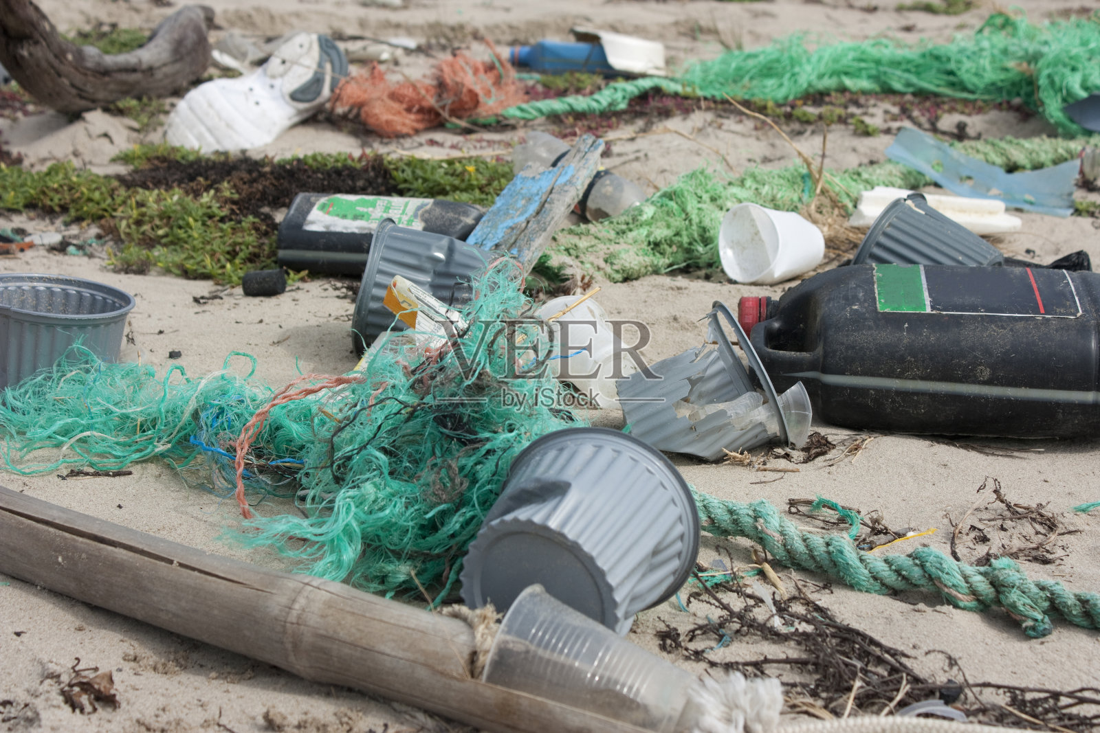 环境污染，垃圾散落在沙滩上照片摄影图片