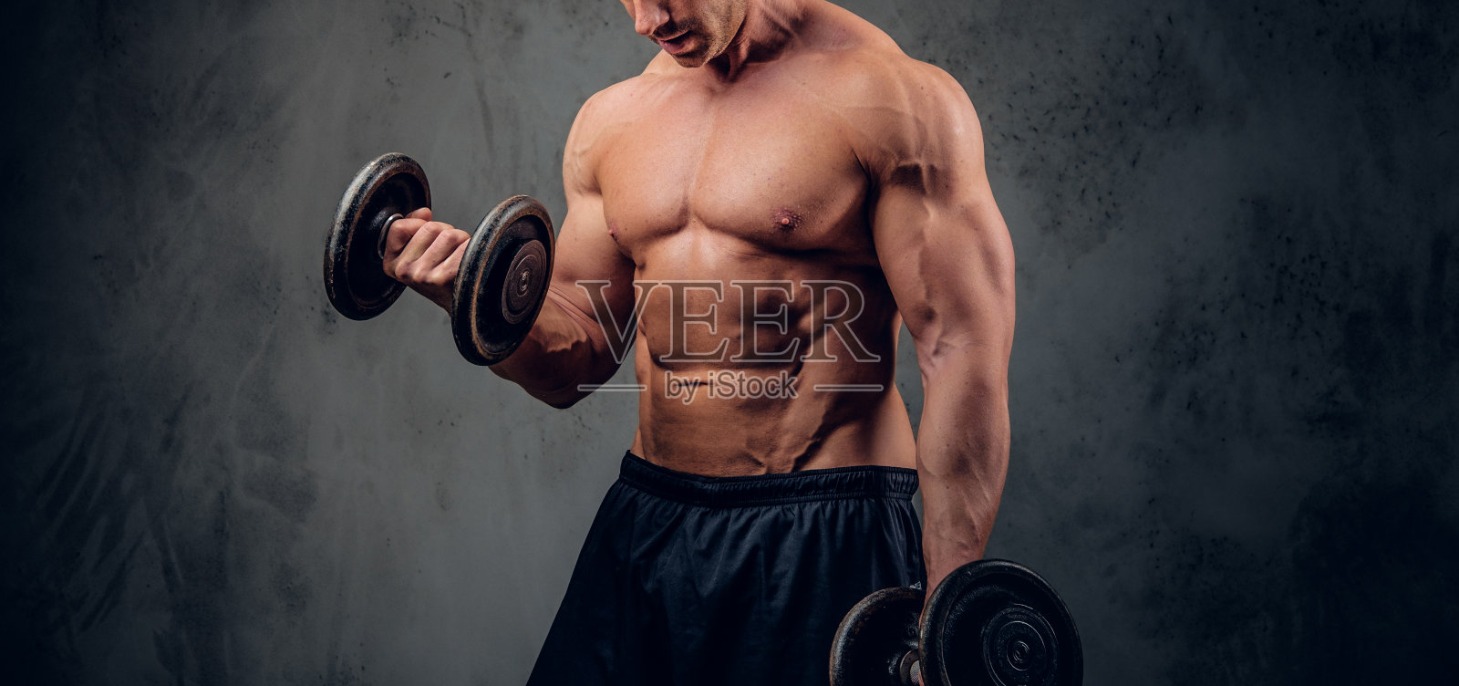 强壮的男性正在练习杠铃在黑暗的背景照片摄影图片