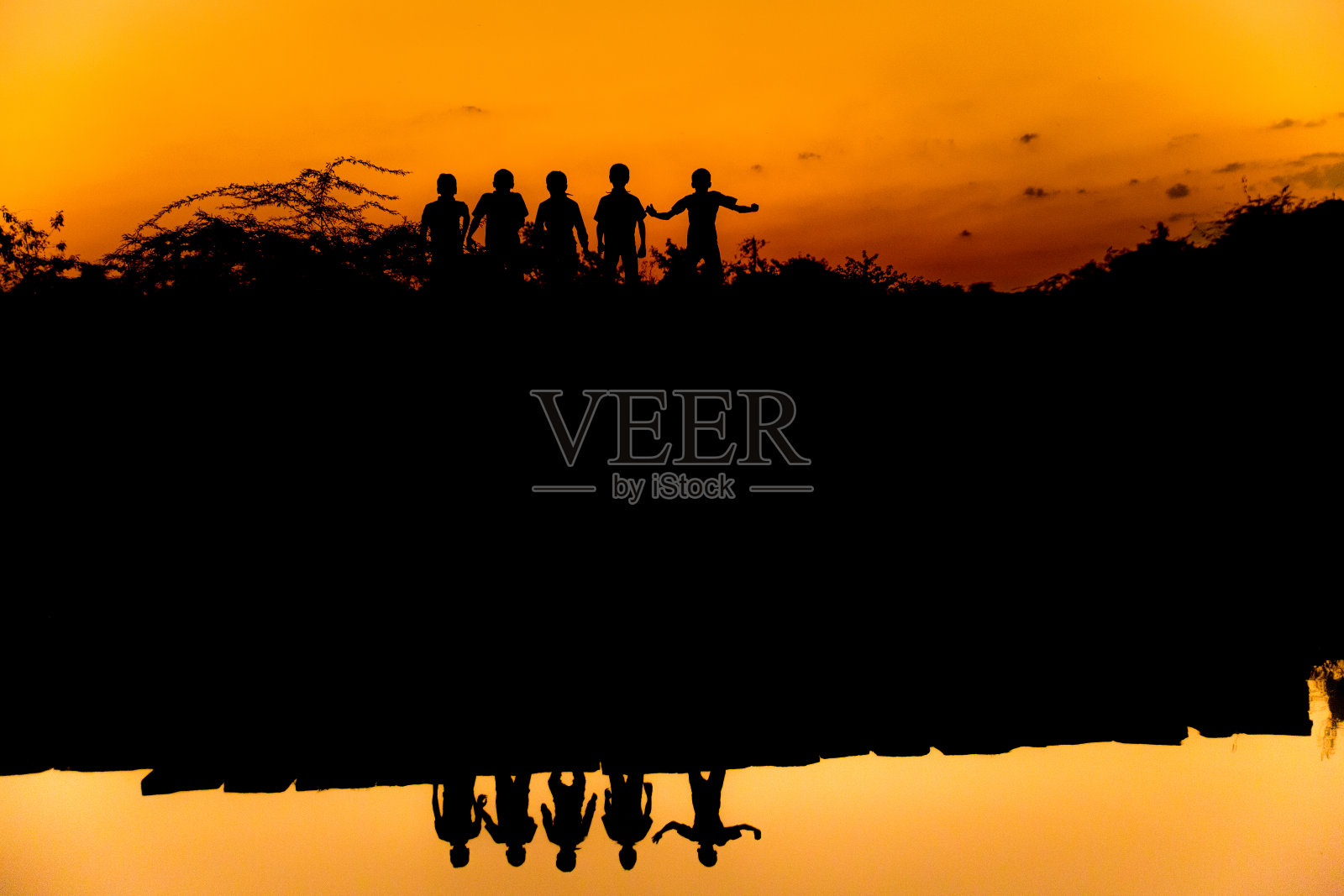 一群徒步旅行者站在湖上的剪影照片摄影图片