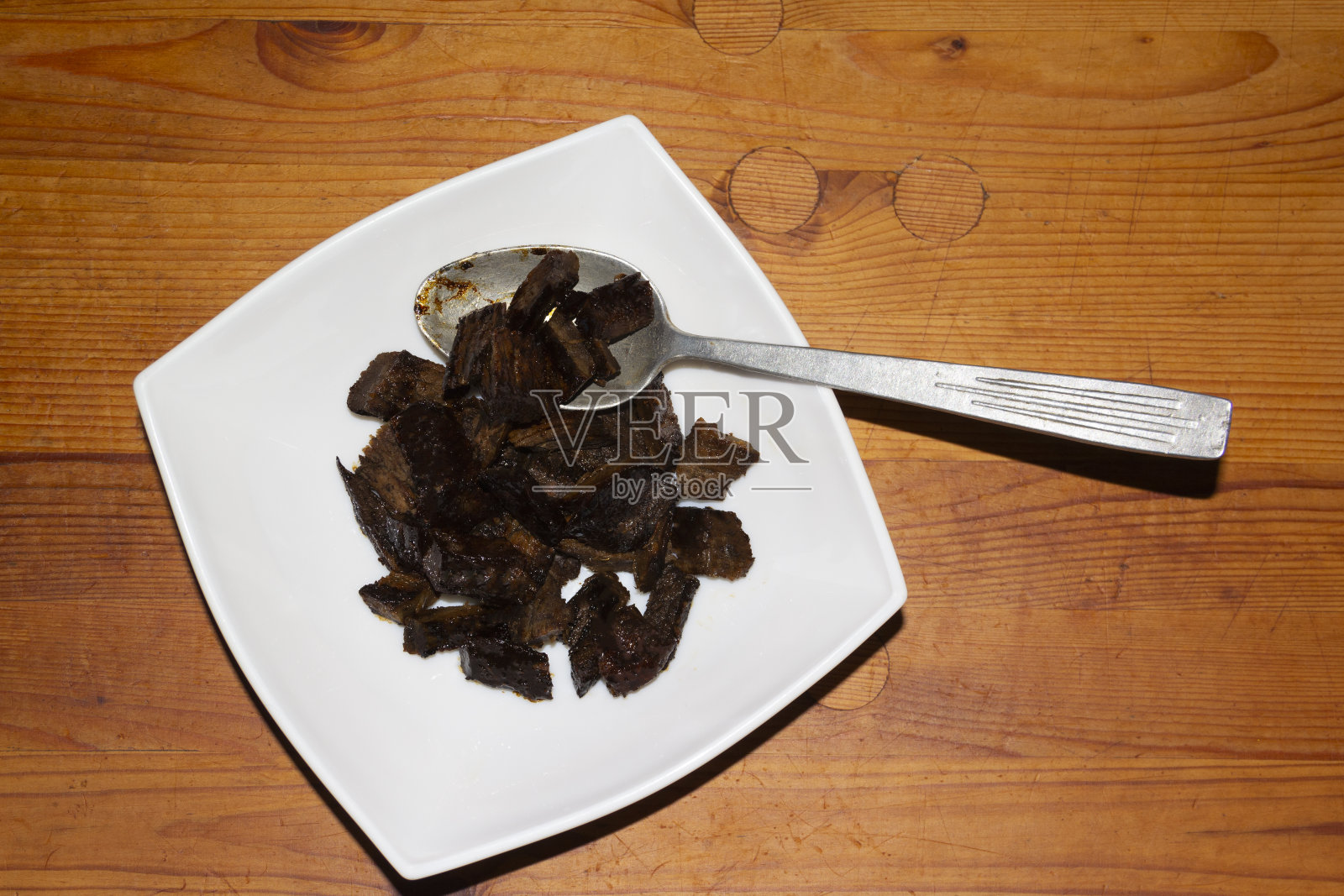 盘子里的一块块烧焦的肉。不能吃的食物。木制的乡村背景。“nHomemade食物。前视图中,背景。乡村照片摄影图片