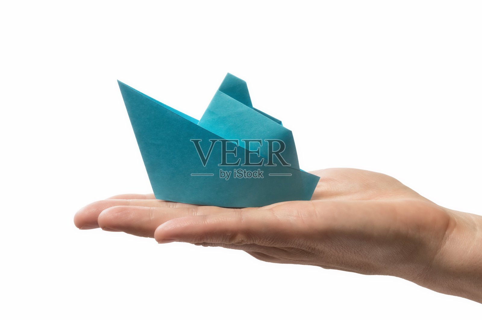 蓝色的纸船在人的手掌。照片摄影图片