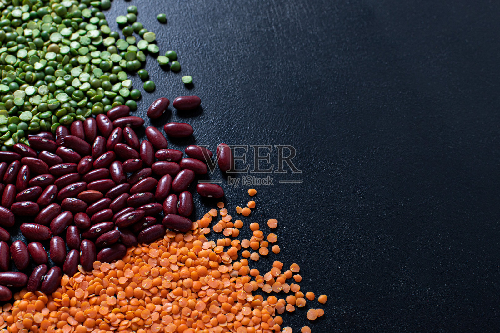 黑背景上的三种豆类：红豆、青豆和橙色小扁豆照片摄影图片