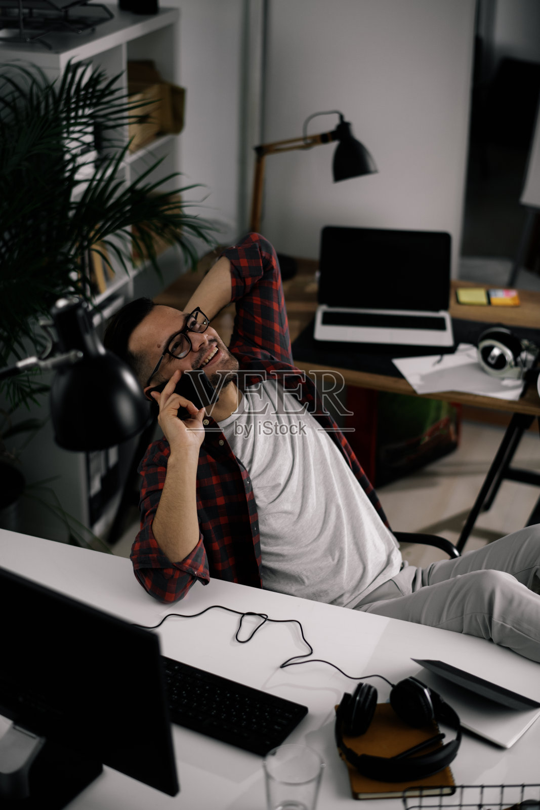 英俊的商人在办公室打电话。照片摄影图片