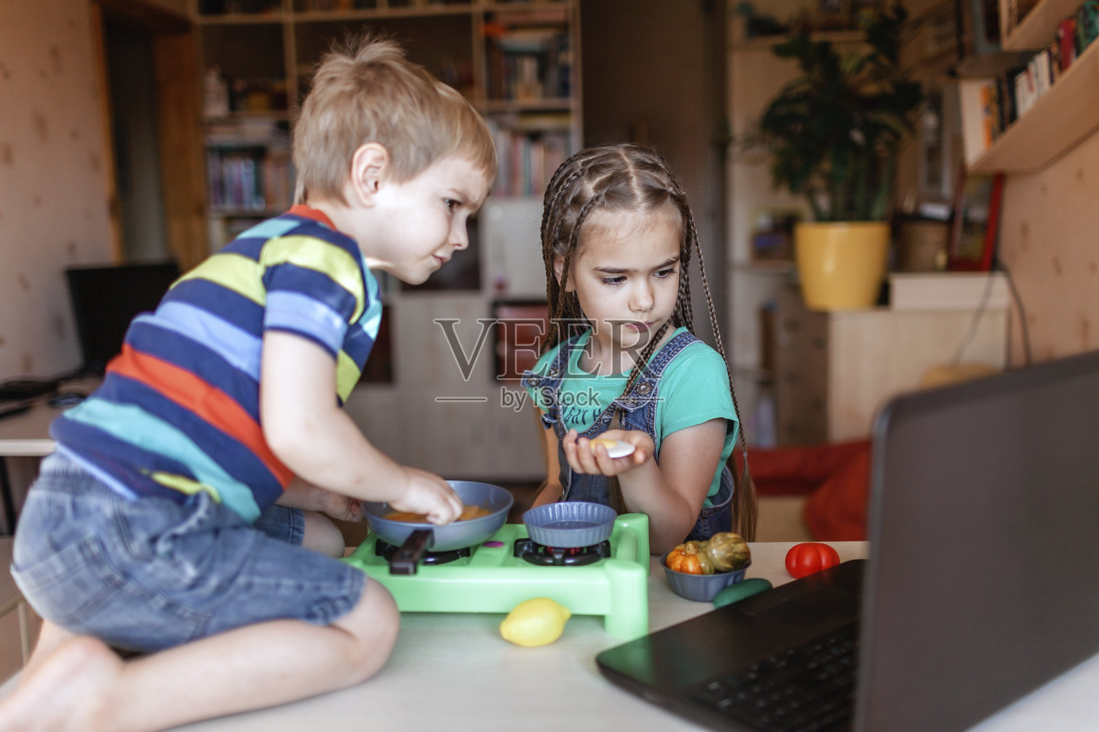 孩子们在笔记本电脑屏幕上观看美食博客视频，并在大师厨师中玩耍照片摄影图片