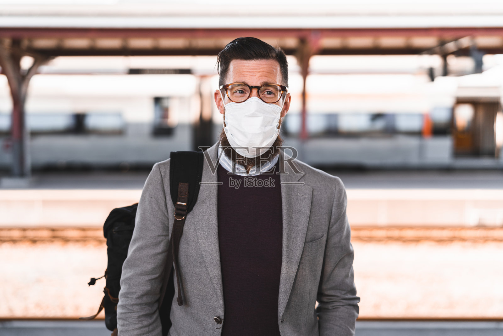 戴着口罩的男性上班族在等火车照片摄影图片