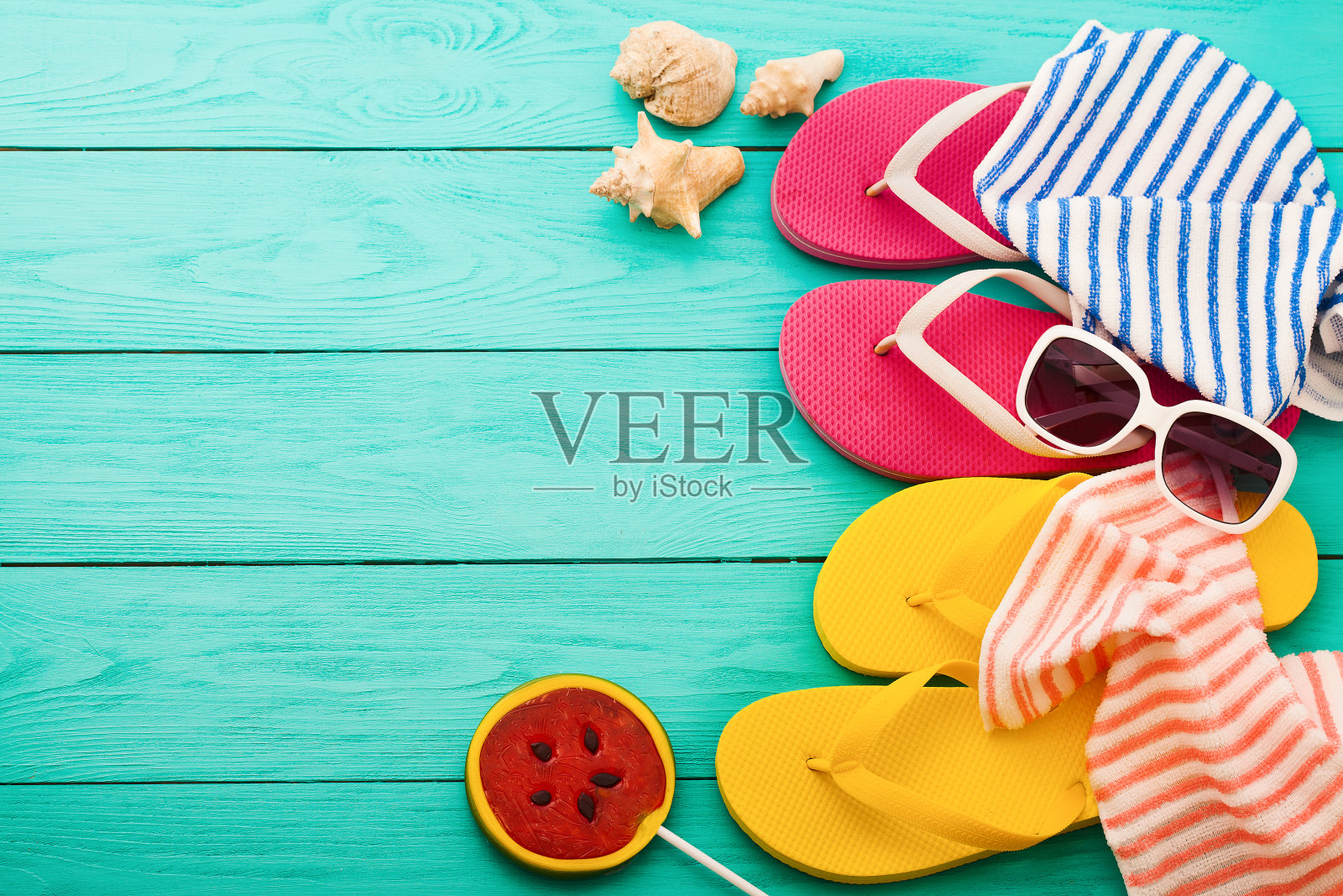 人字拖，毛巾和西瓜夏天糖果食物在蓝色的木制背景。前视图。模拟。副本的空间。甜的棒棒糖照片摄影图片