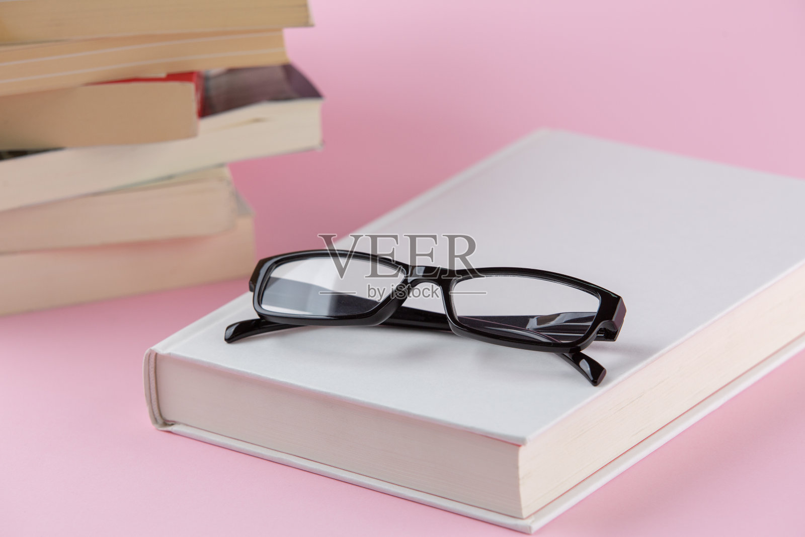 上面有白色热罩和老花镜的书。照片摄影图片