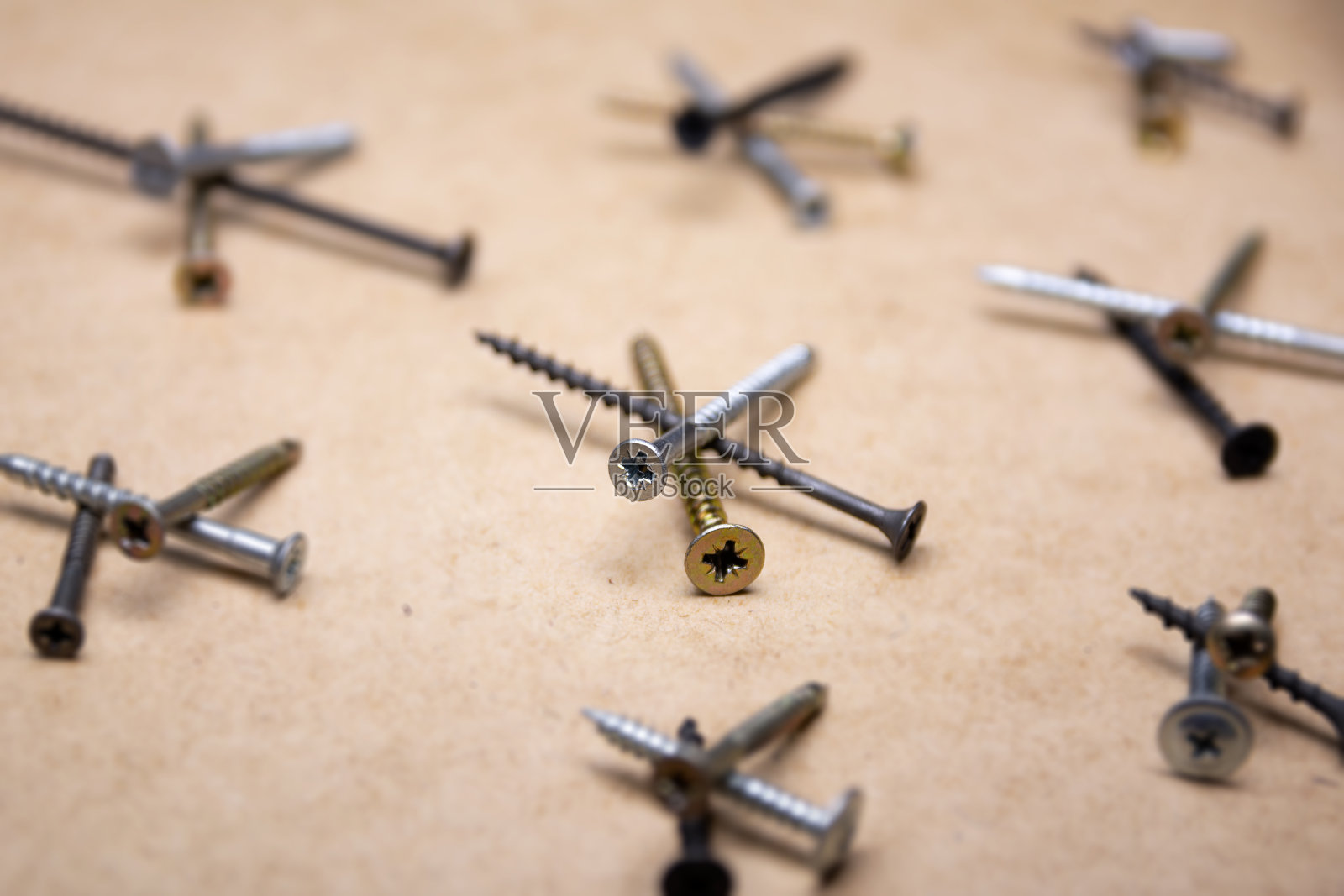 木制背景上的金色和黑色螺丝照片摄影图片