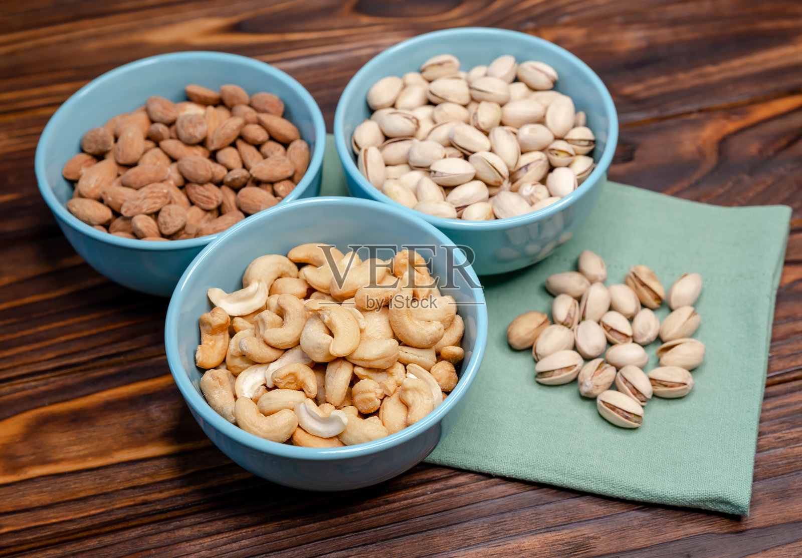 混合坚果放在一张古老的乡村桌子上。黄金开心果，腰果，杏仁照片摄影图片