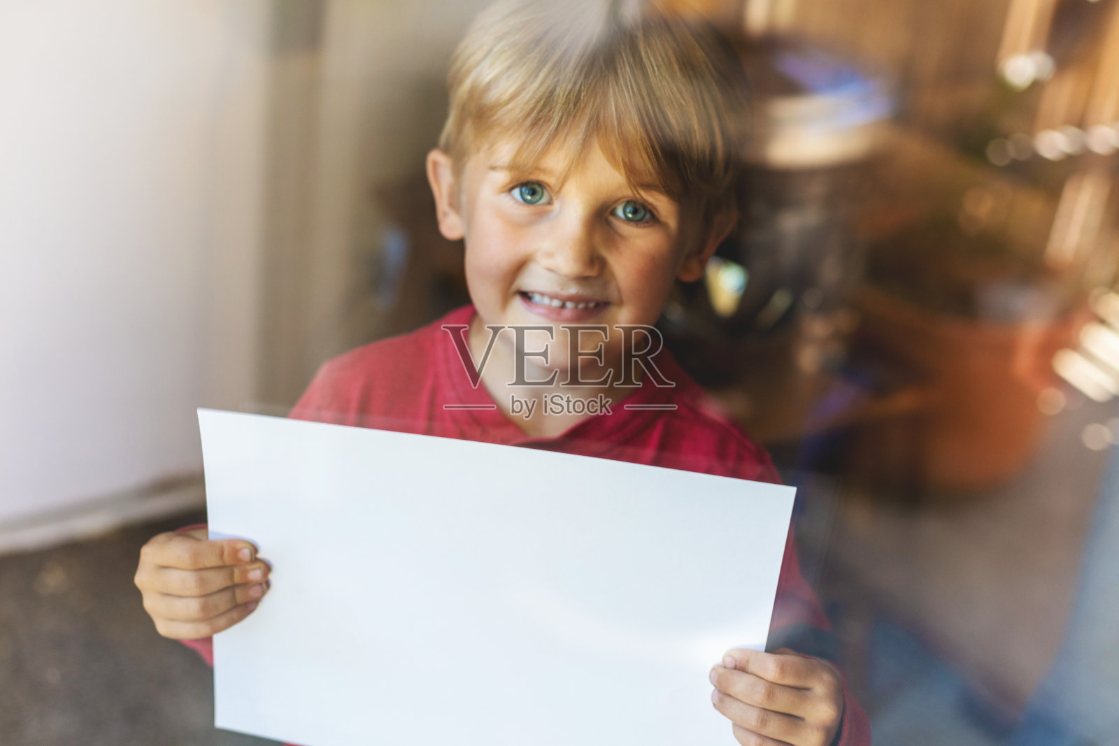 在流感大流行期间，一名男孩在室内举着牌子照片摄影图片