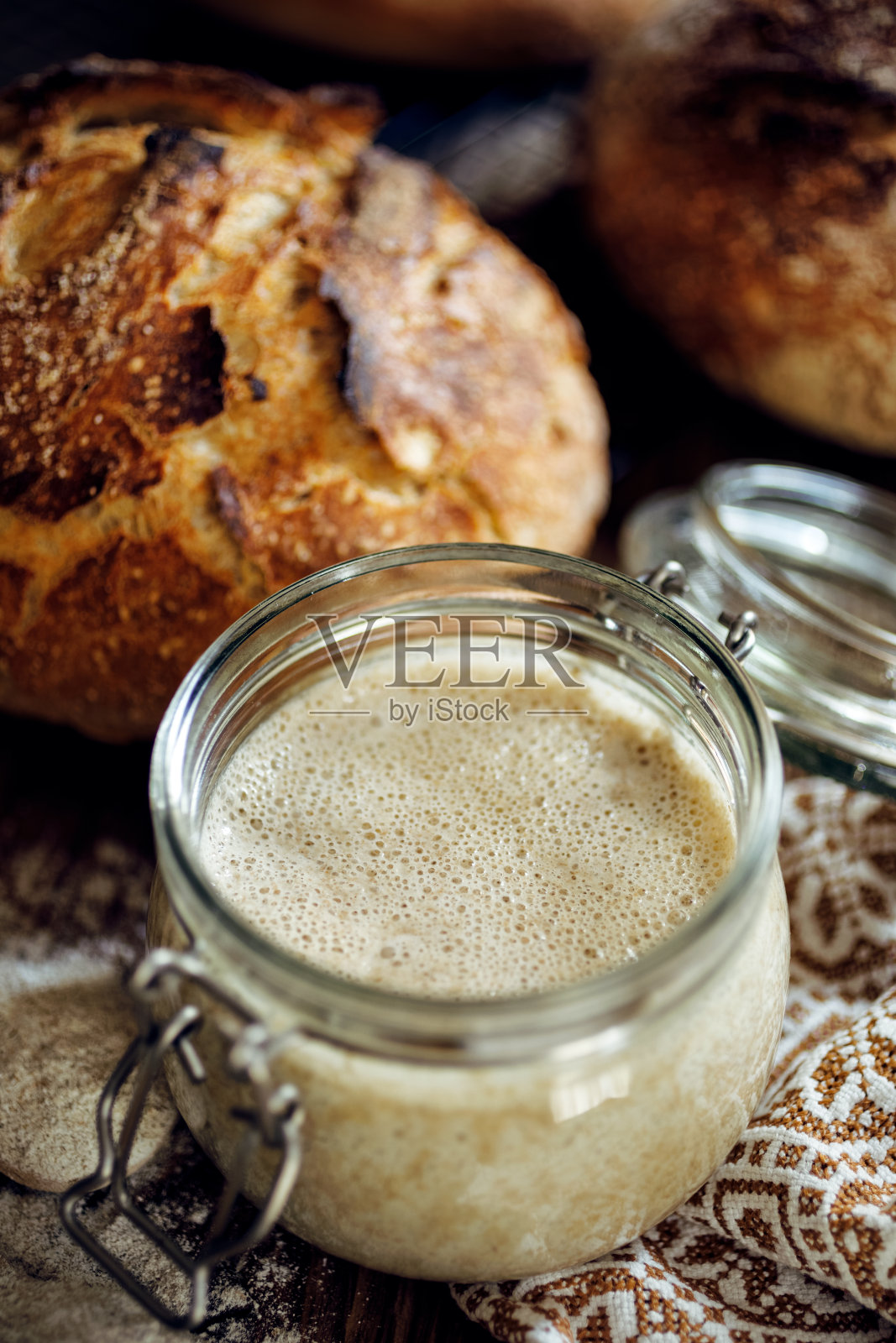 木桌上用于烤面包的活性黑麦酵母罐照片摄影图片