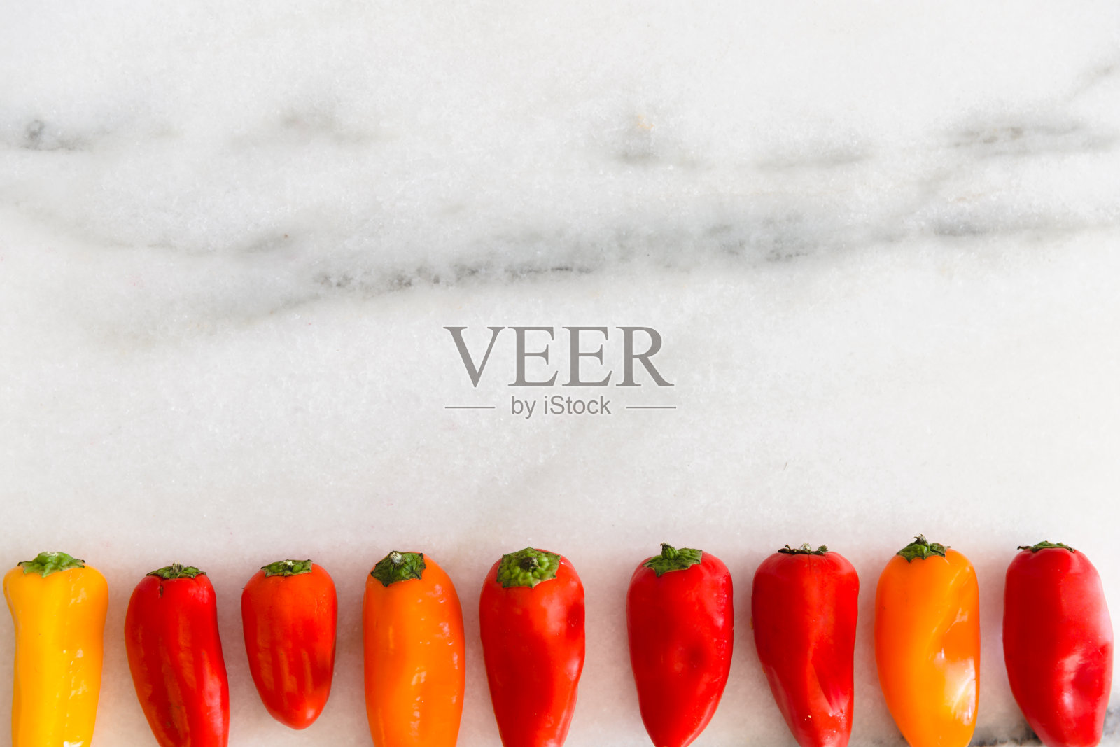 大理石表面上五颜六色的小甜椒。照片摄影图片