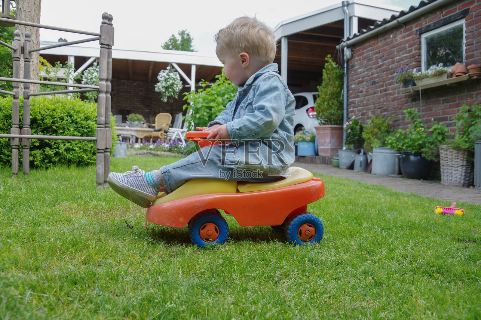 蹒跚学步的孩子在玩他的玩具车照片摄影图片