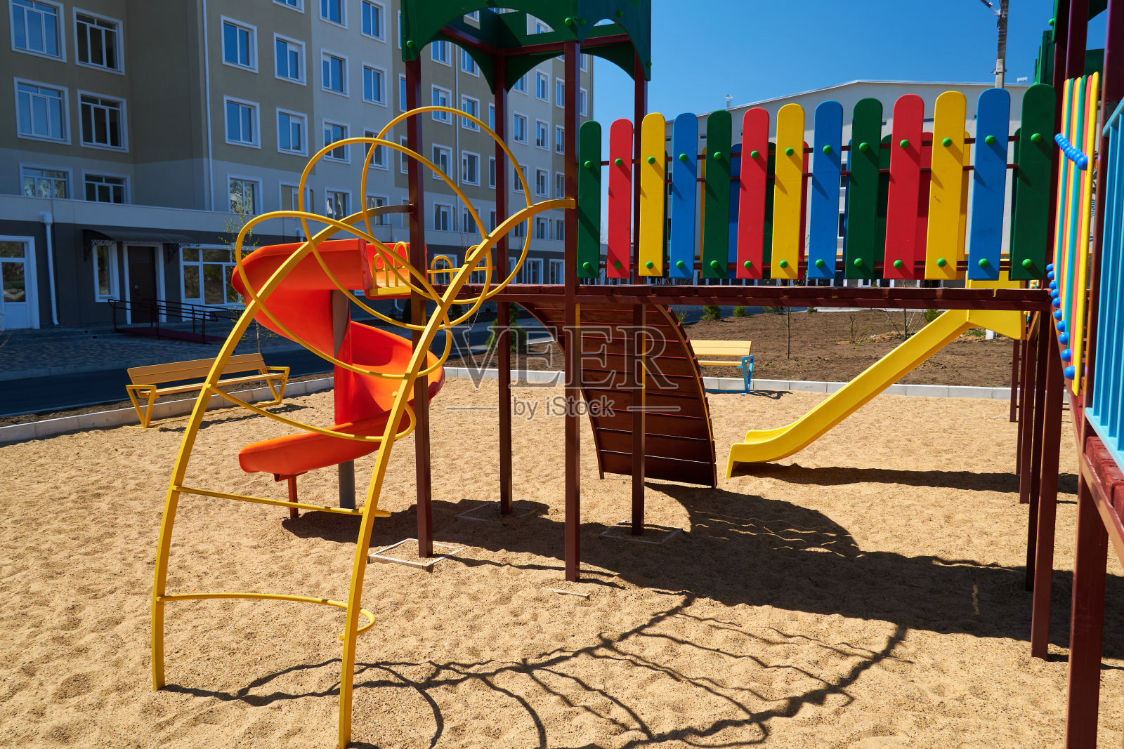 城市居民的基础设施没有人-儿童游乐场旁边的公寓。秋千，滑梯，楼梯，多层建筑。孩子们玩耍的地方。照片摄影图片