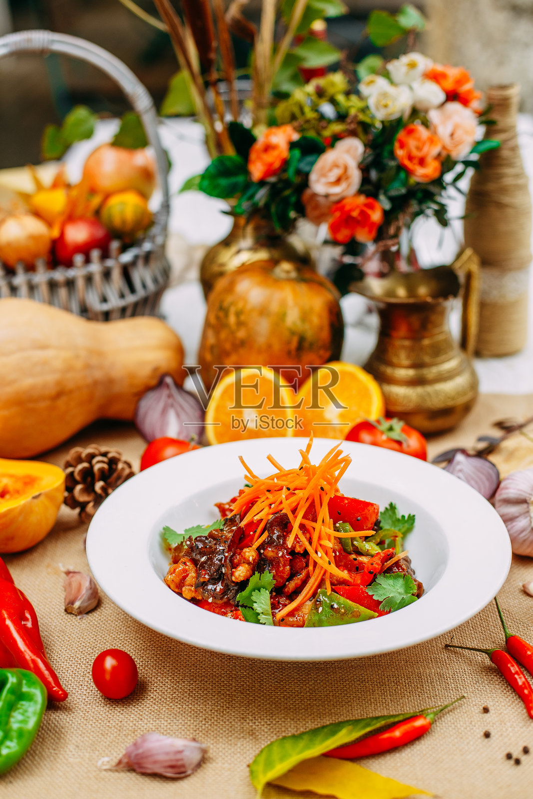 秋季餐桌上的南瓜。感恩节晚餐。热沙拉，茄子鸡柳面糊，木香菇，苦椒，番茄照片摄影图片