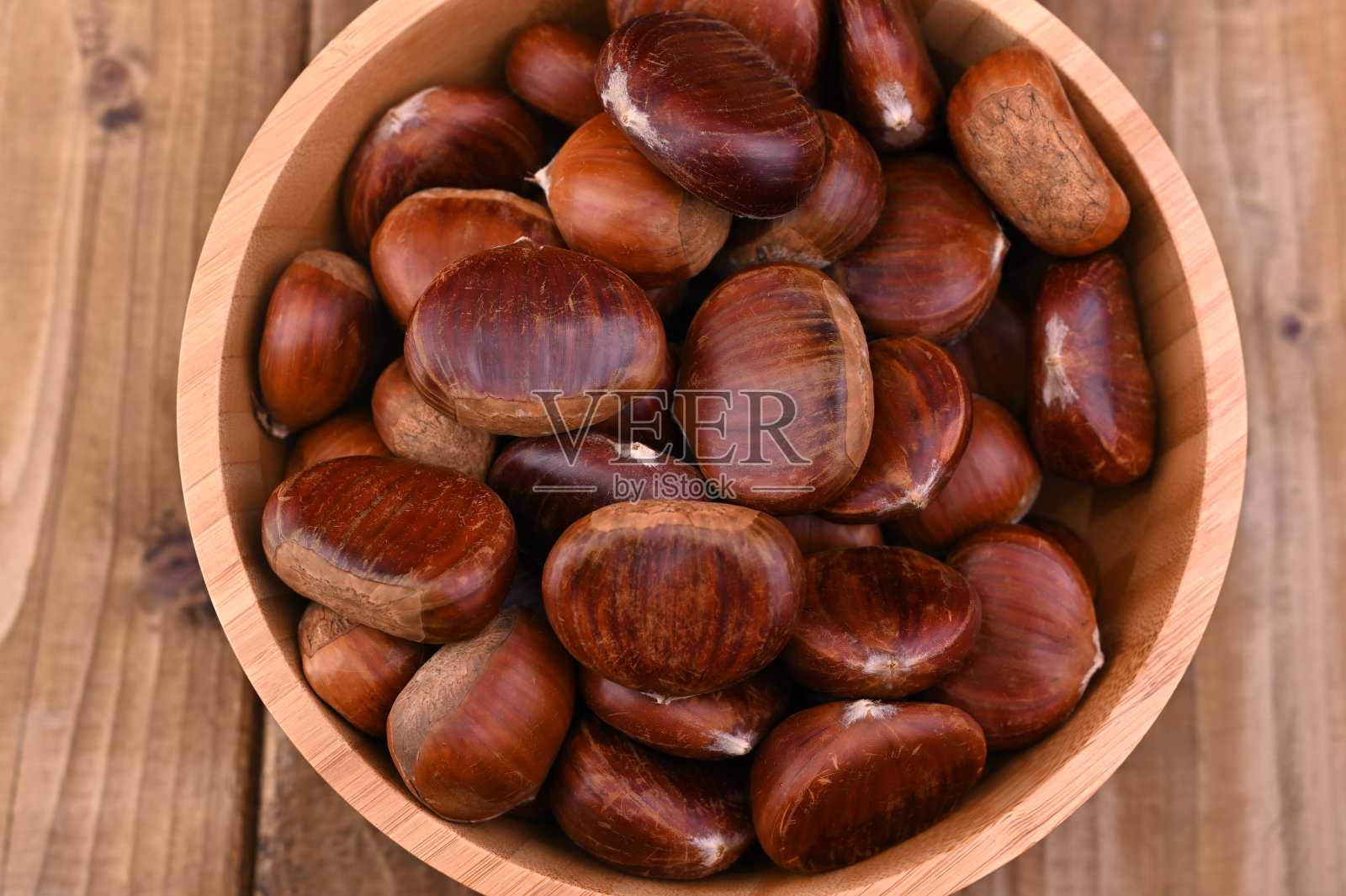 一杯栗子放在木头背景上。秋收，果实成熟。文本的空闲空间。照片摄影图片