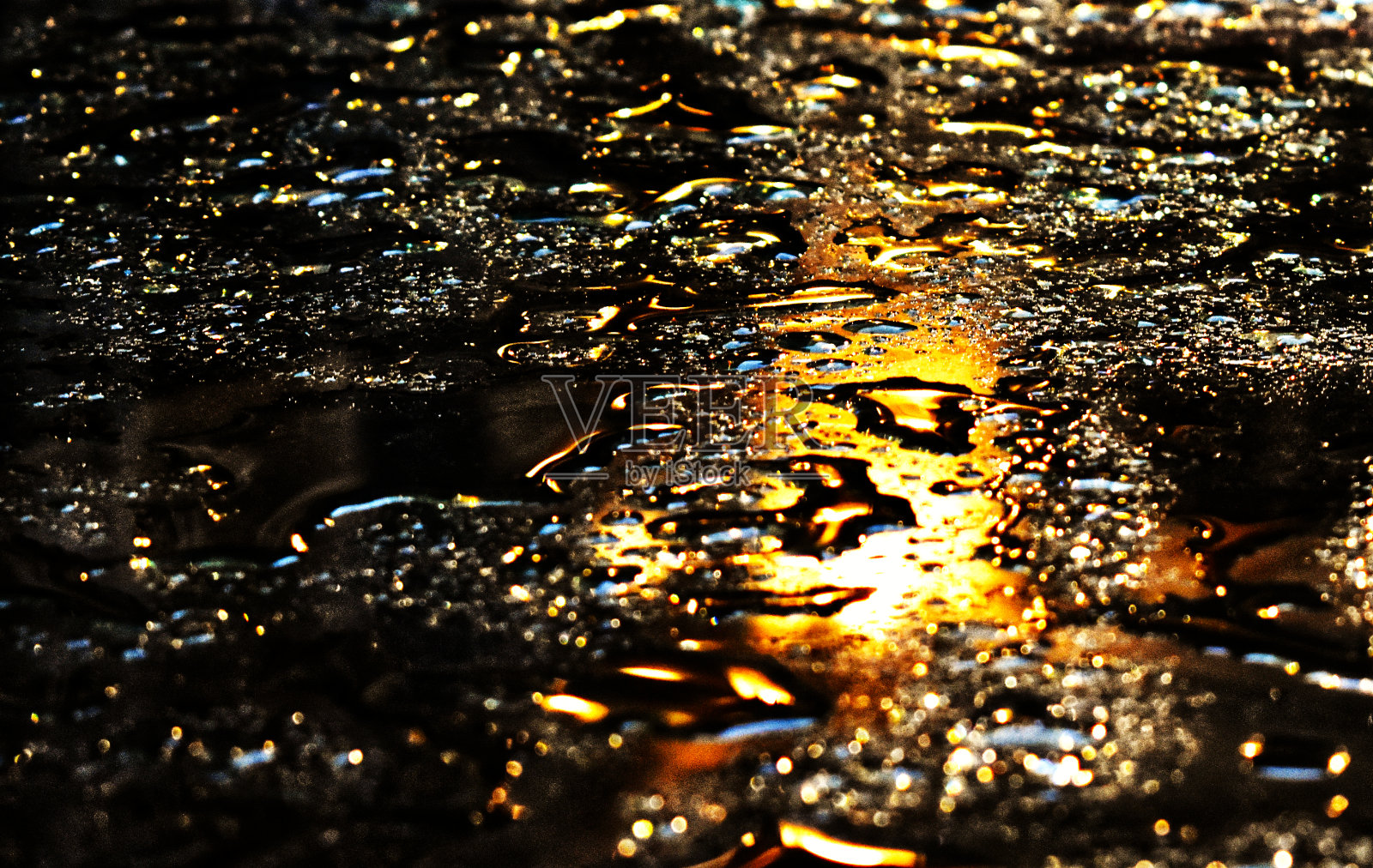 被照亮的雨滴落在玻璃桌上照片摄影图片