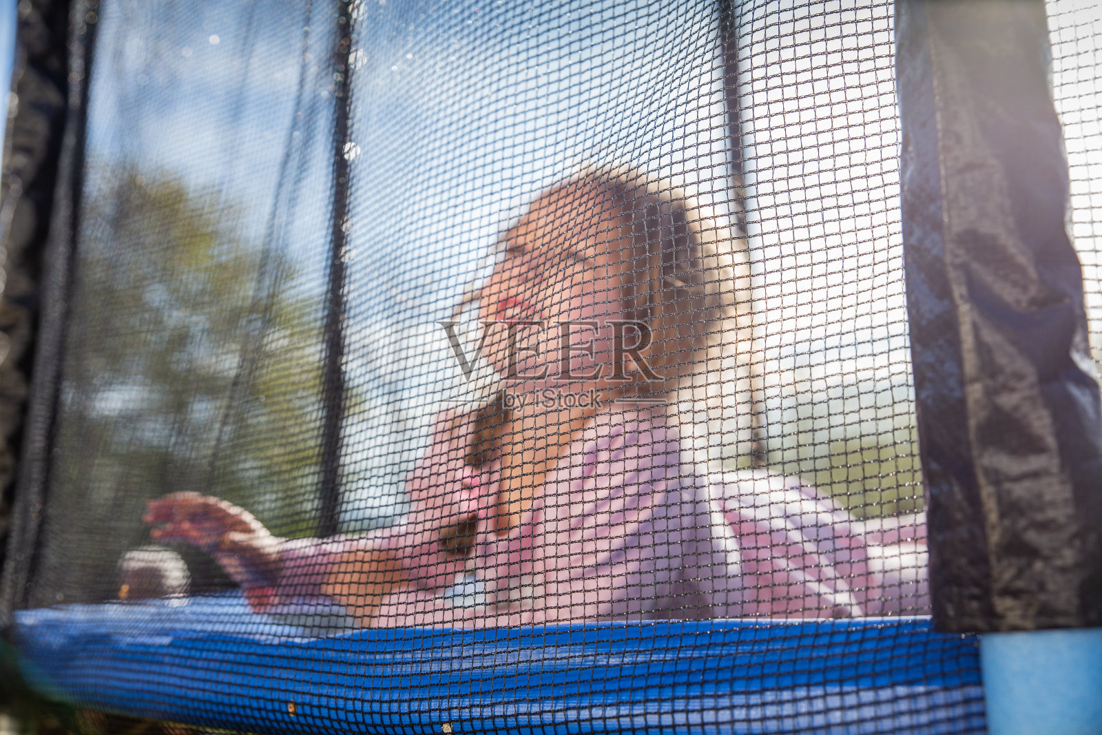 小女孩在蹦床上照片摄影图片