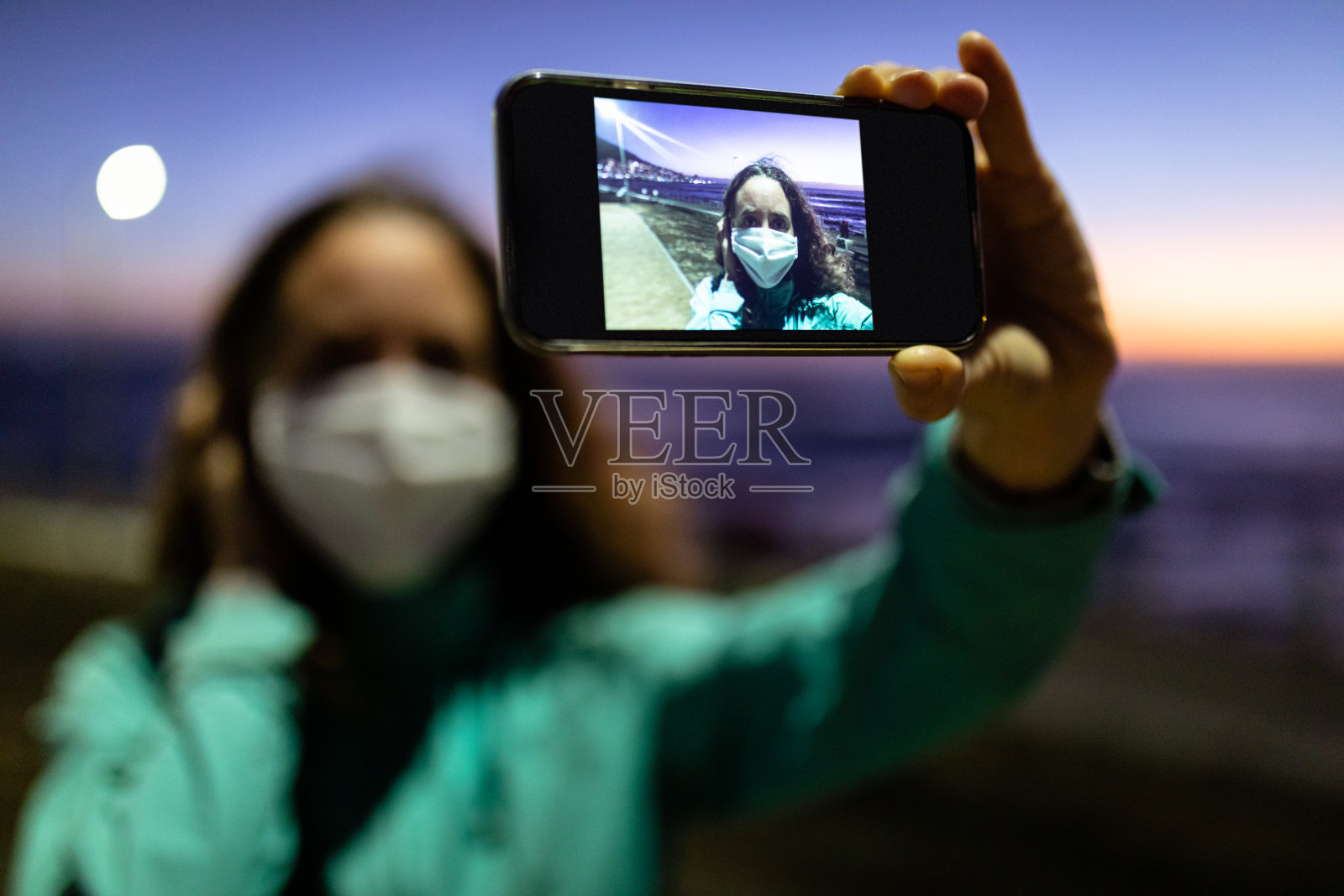 一名白人妇女戴着防冠状病毒的面罩，在街上拍照照片摄影图片