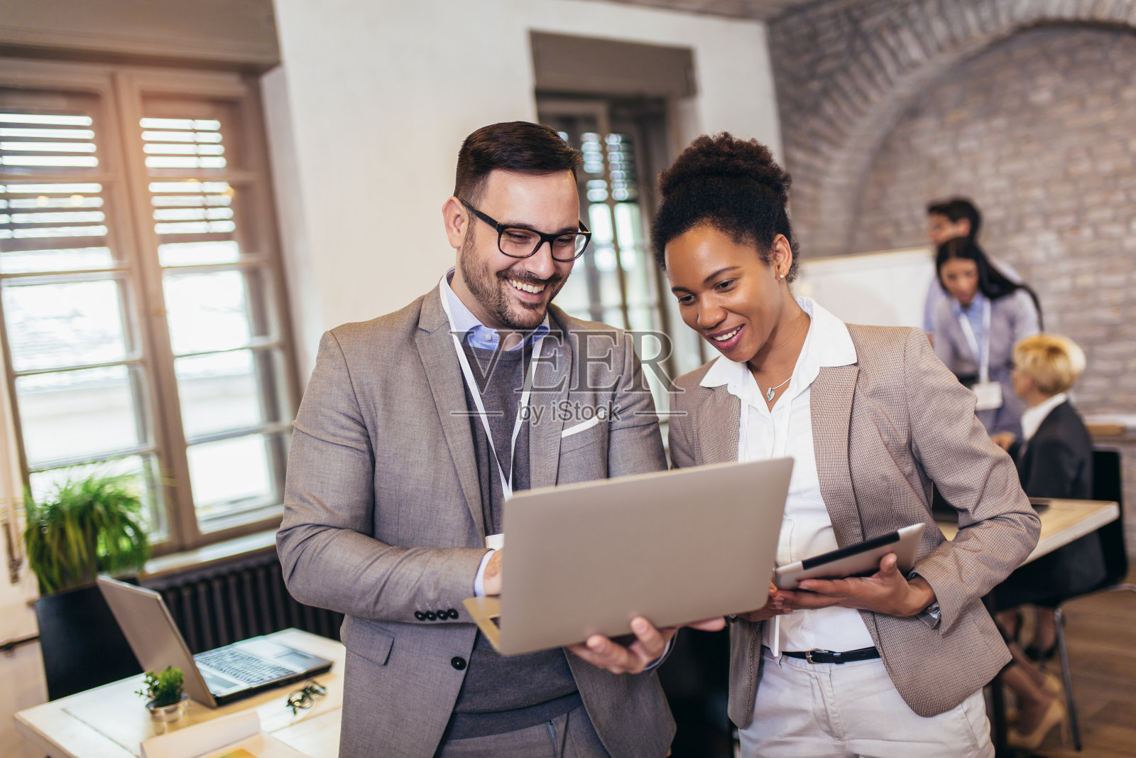 在现代化的办公室里，商业同事讨论新想法，进行头脑风暴照片摄影图片