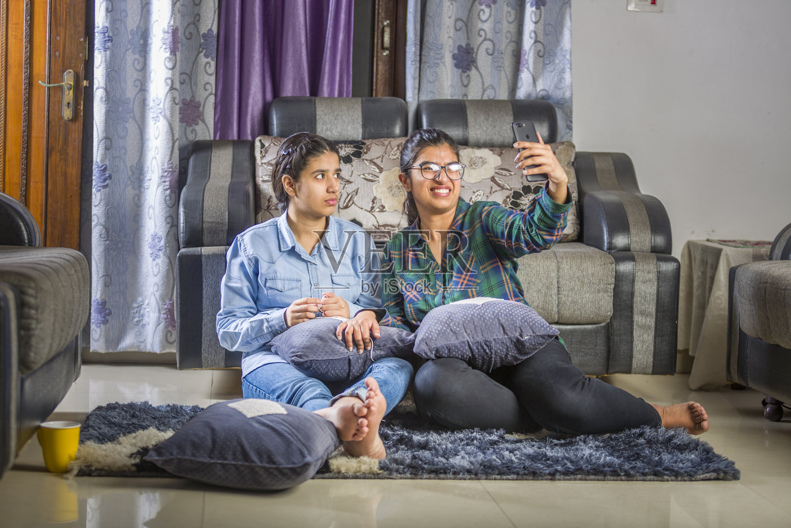 两个女孩坐在家里自拍，玩得很开心照片摄影图片