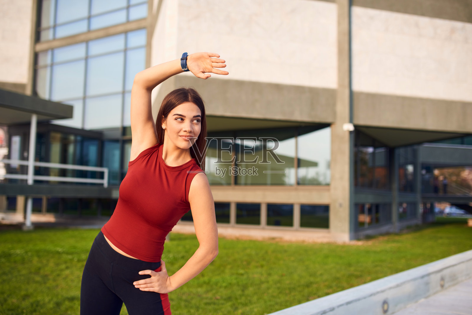 年轻女子在城市公园做运动/伸展运动。照片摄影图片