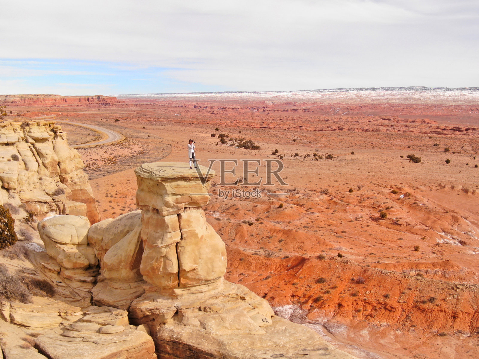 无人机:一名女子站在砂岩地层顶部拍摄峡谷照片照片摄影图片