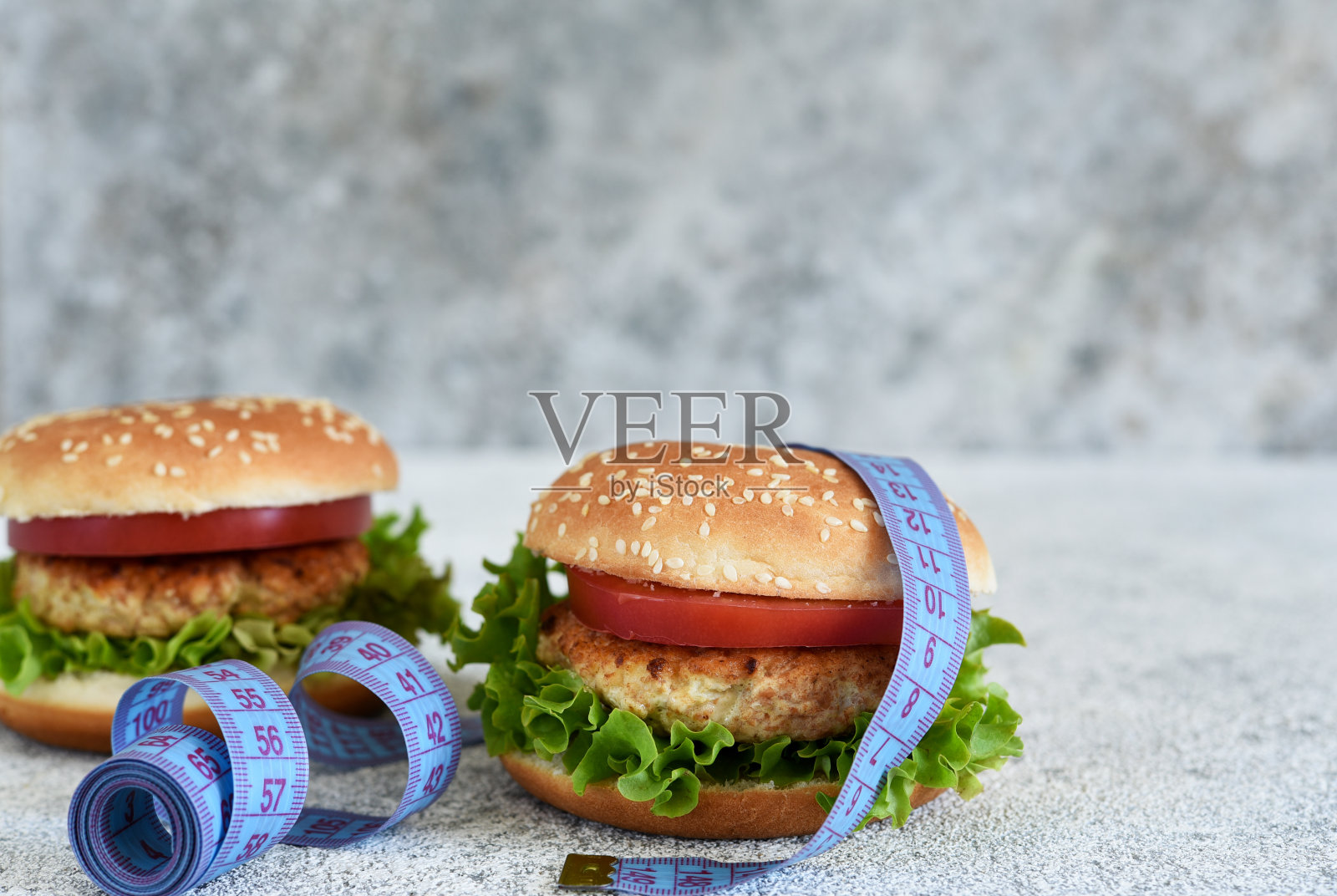 大汉堡，混凝土背景上有厘米。大的卡路里。健康。照片摄影图片