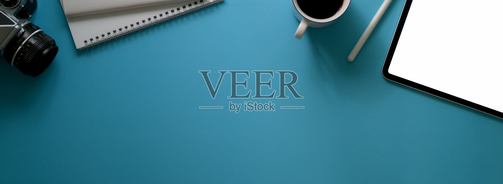 俯视图创意工作空间与空白屏幕平板电脑，咖啡杯，日记笔记本，相机和复制空间照片摄影图片