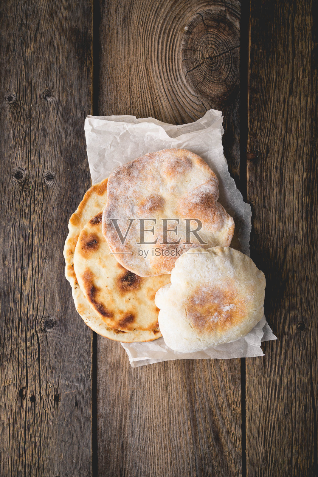 木桌上放着新鲜的皮塔饼照片摄影图片