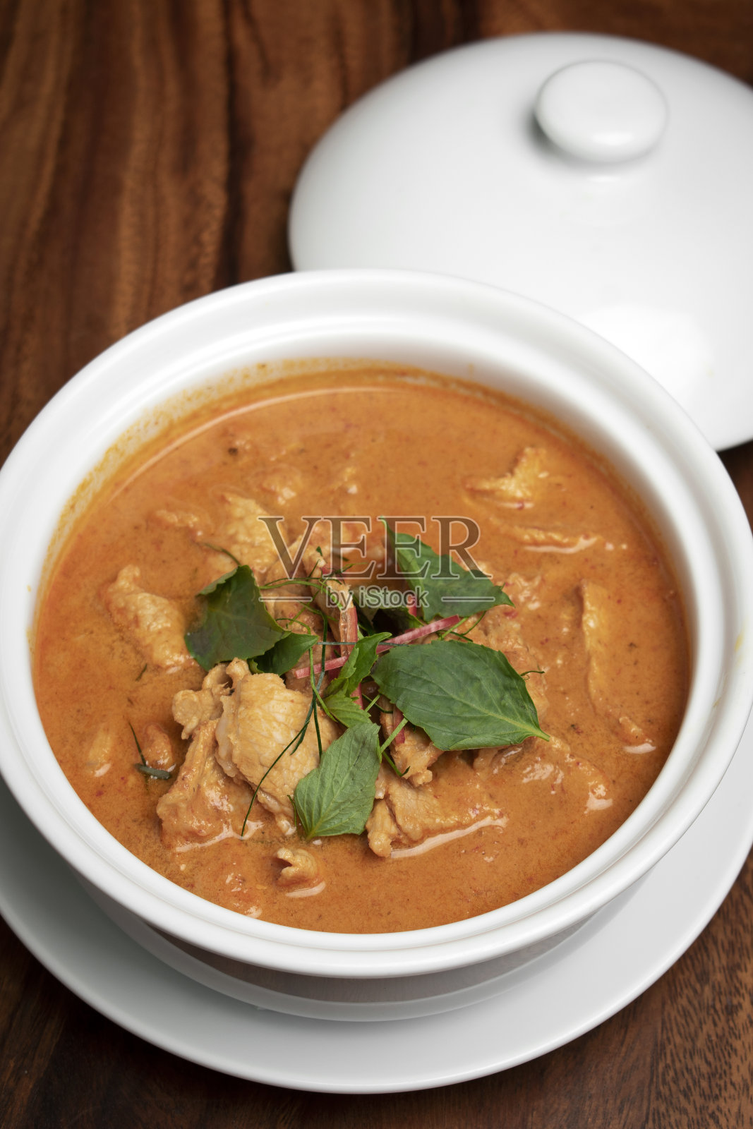 泰国普吉岛的一张木桌上放着泰国辣咖喱肉和椰奶照片摄影图片