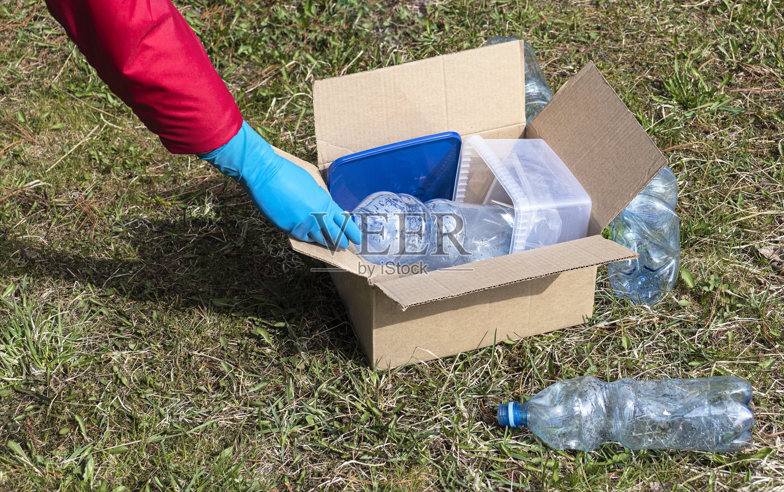 这个女孩用盒子收集塑料垃圾。环境保护照片摄影图片