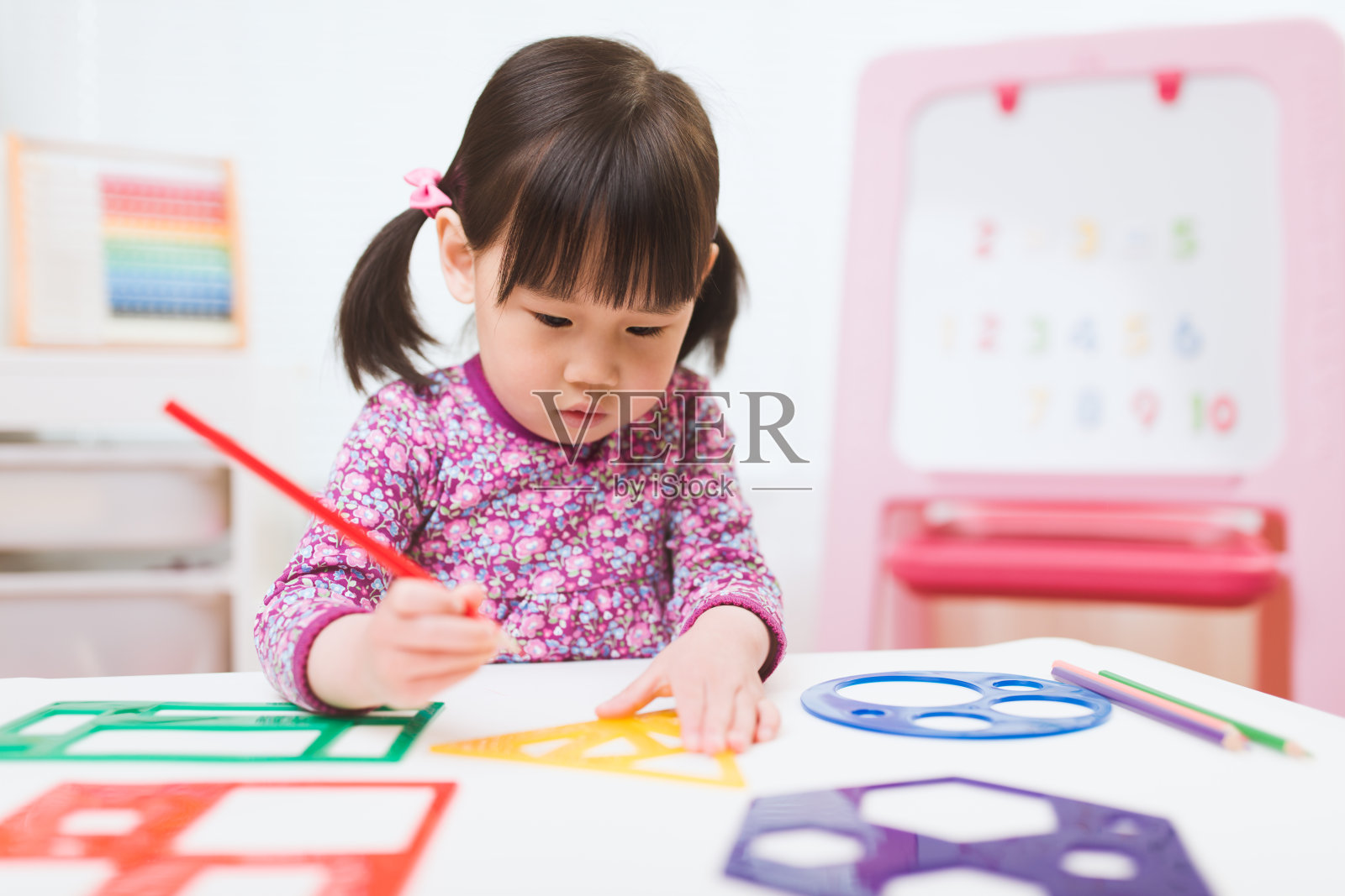 蹒跚学步的女孩练习画不同的形状在家上学照片摄影图片