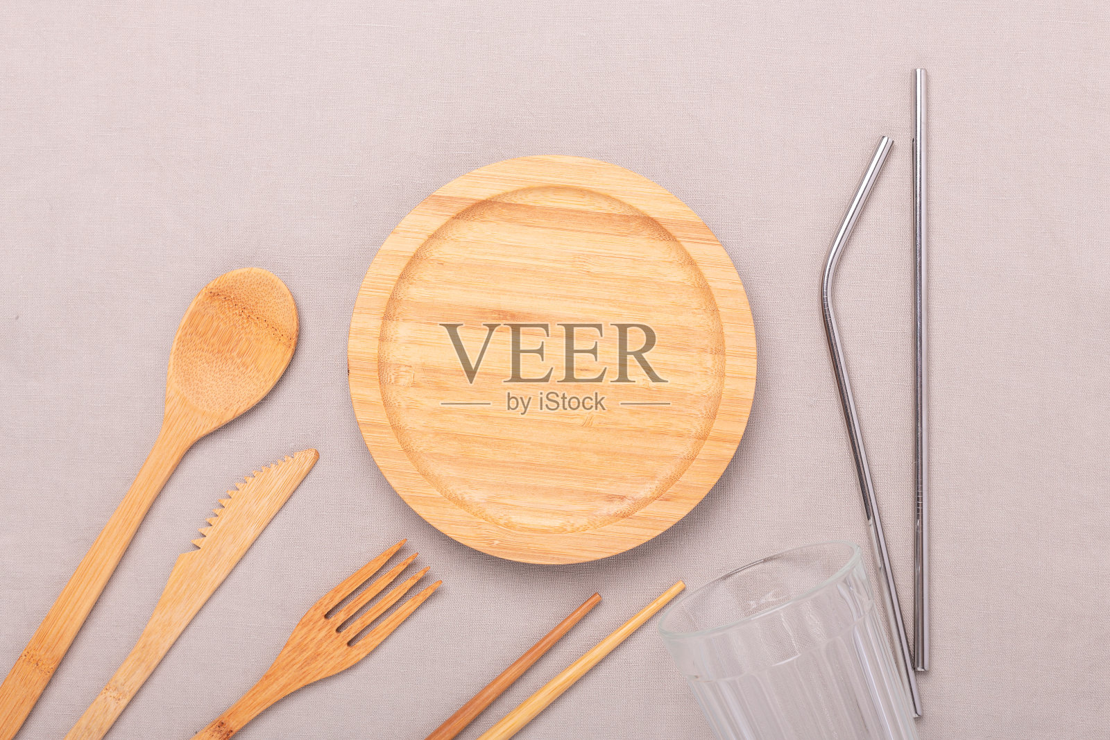 零浪费，无塑料的概念。木盘，玻璃杯，竹制餐具一套。平铺在织物亚麻布背景上照片摄影图片