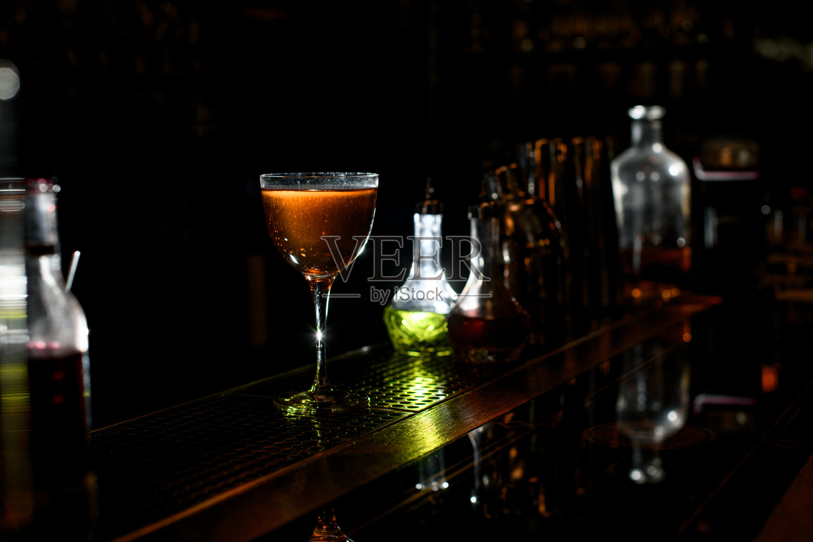 在餐厅的酒吧里，放着一杯棕色的酒精饮料。照片摄影图片