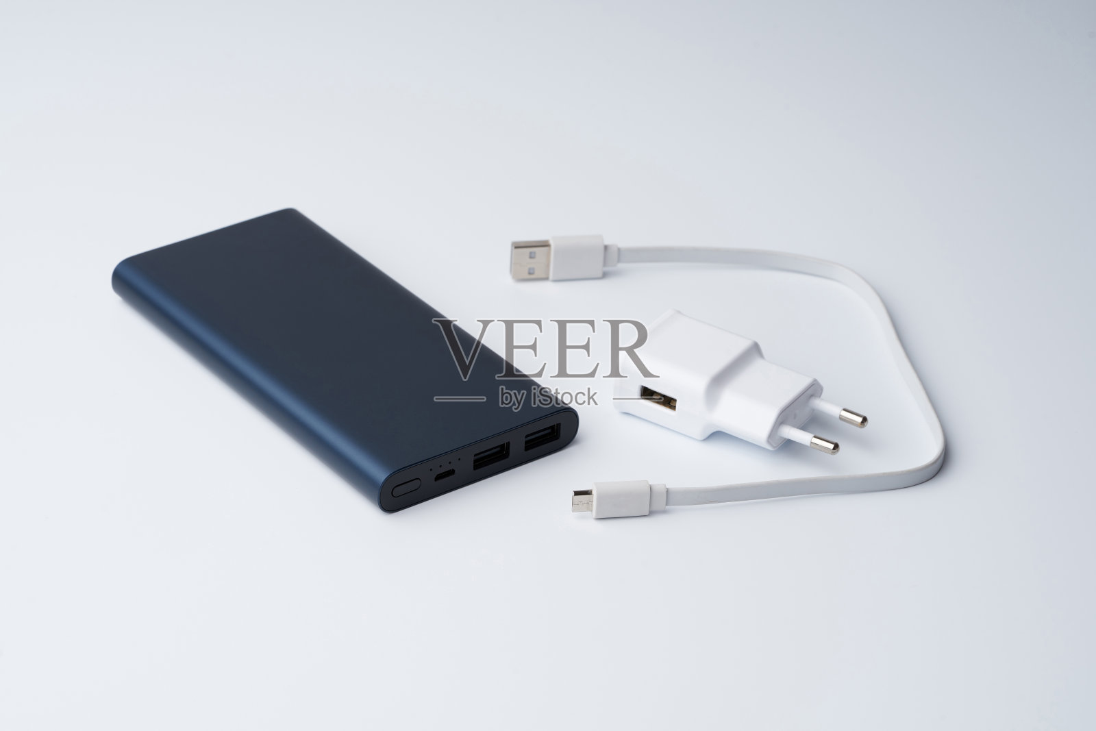 白色USB电源适配器，电缆和蓝色电源组的设备隔离在白色背景。照片摄影图片