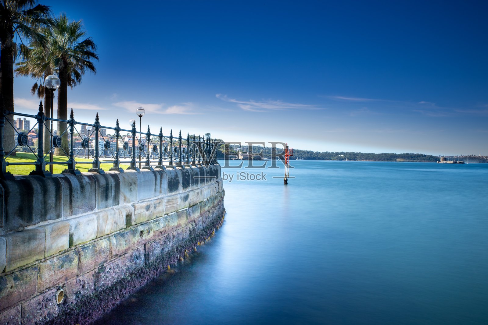 长时间暴露在澳大利亚悉尼港晴朗的蓝天与蓝绿色的海湾照片摄影图片