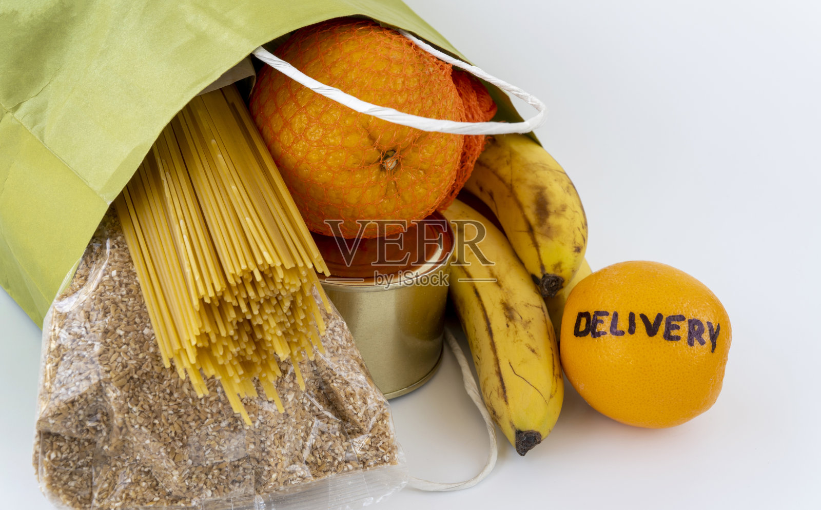 新冠肺炎隔离期间的食品配送。产品在一个纸袋。以现金支付服务费用。大流行期间的自我隔离模式，待在家里。照片摄影图片