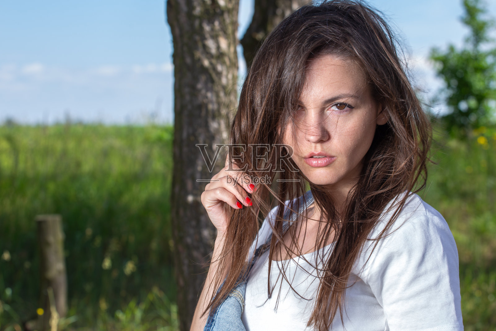 森林里穿着白色t恤和牛仔裤的美女照片摄影图片