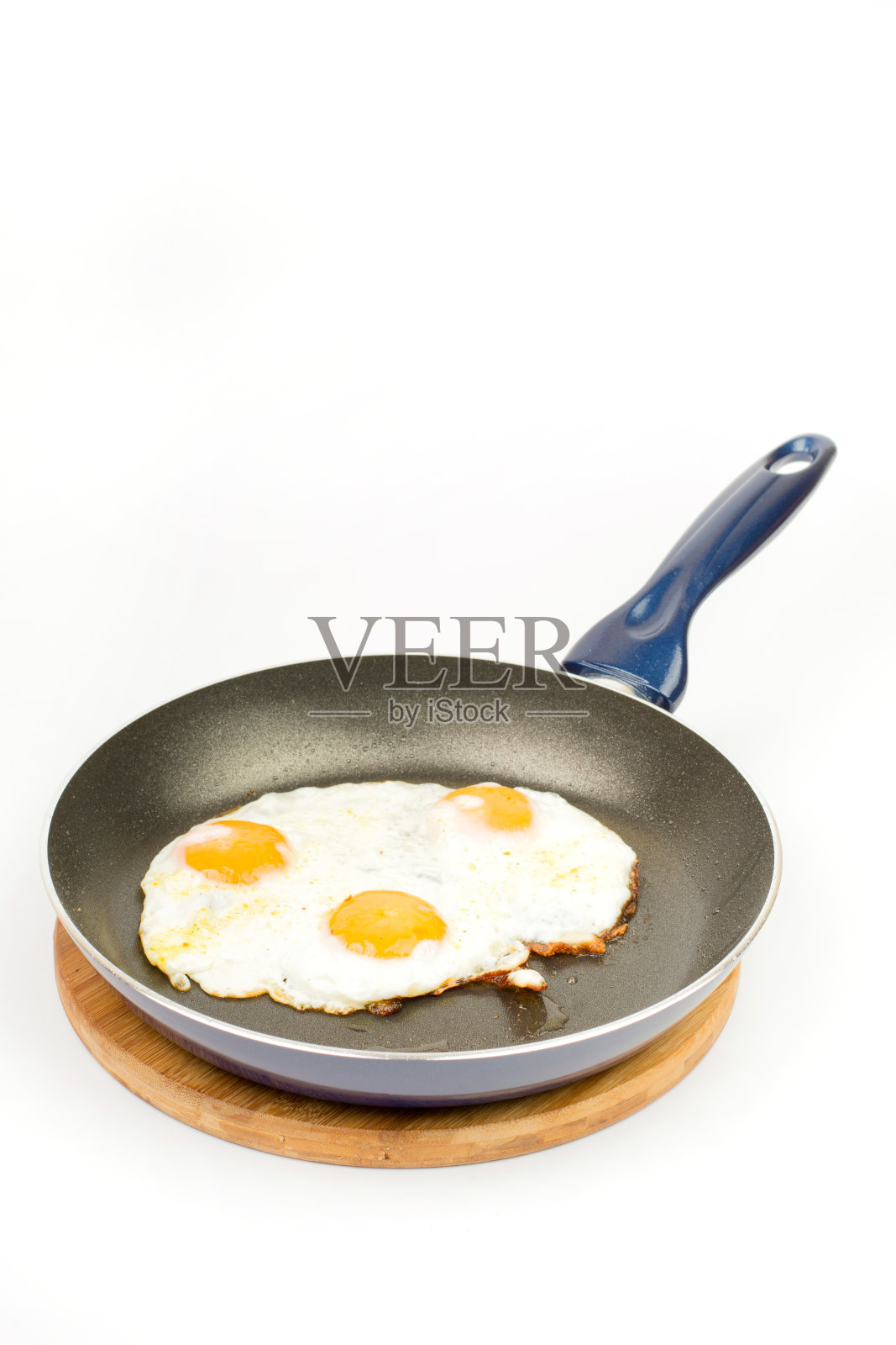 用特氟隆平底锅煎鸡蛋，背景白色照片摄影图片