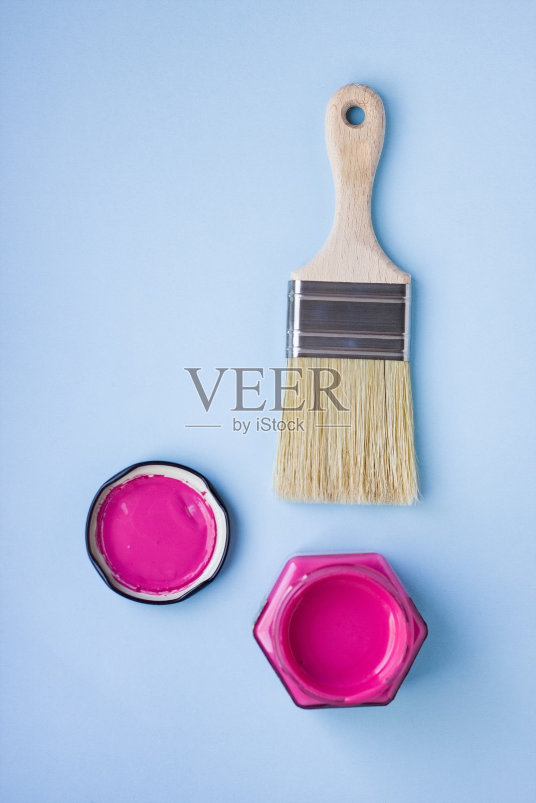油漆罐与紫色和画笔在蓝色的背景。房子装修。的爱好。照片摄影图片