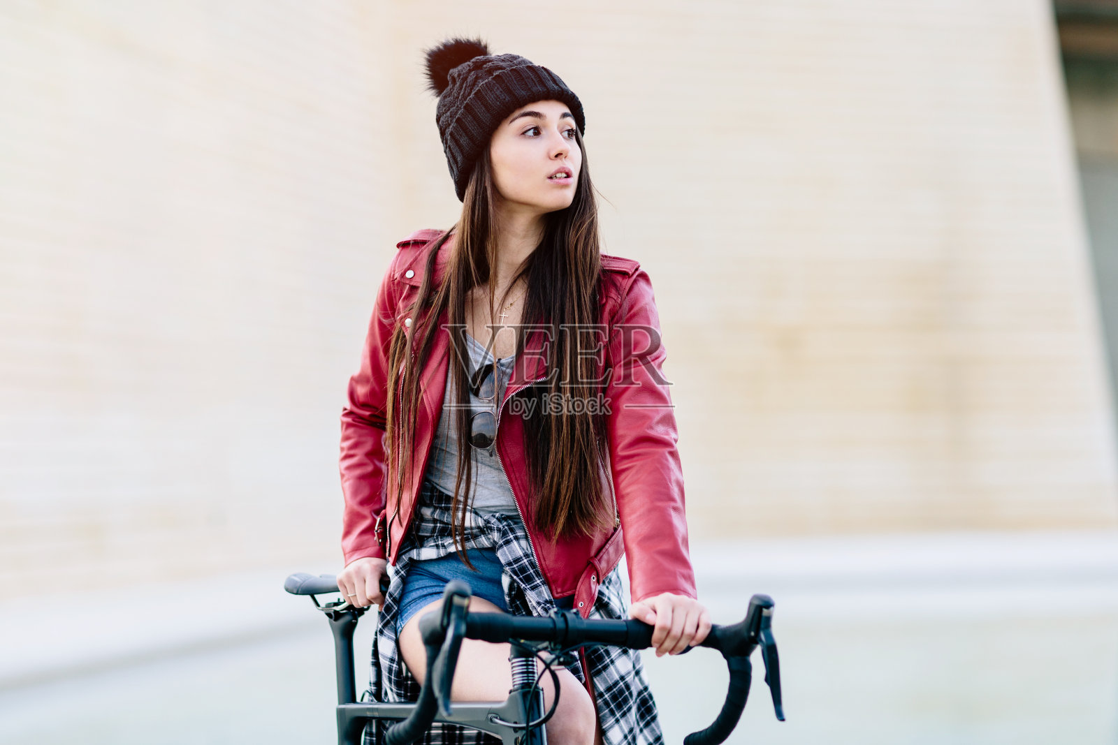 嬉皮士女孩靠在自行车上等着照片摄影图片