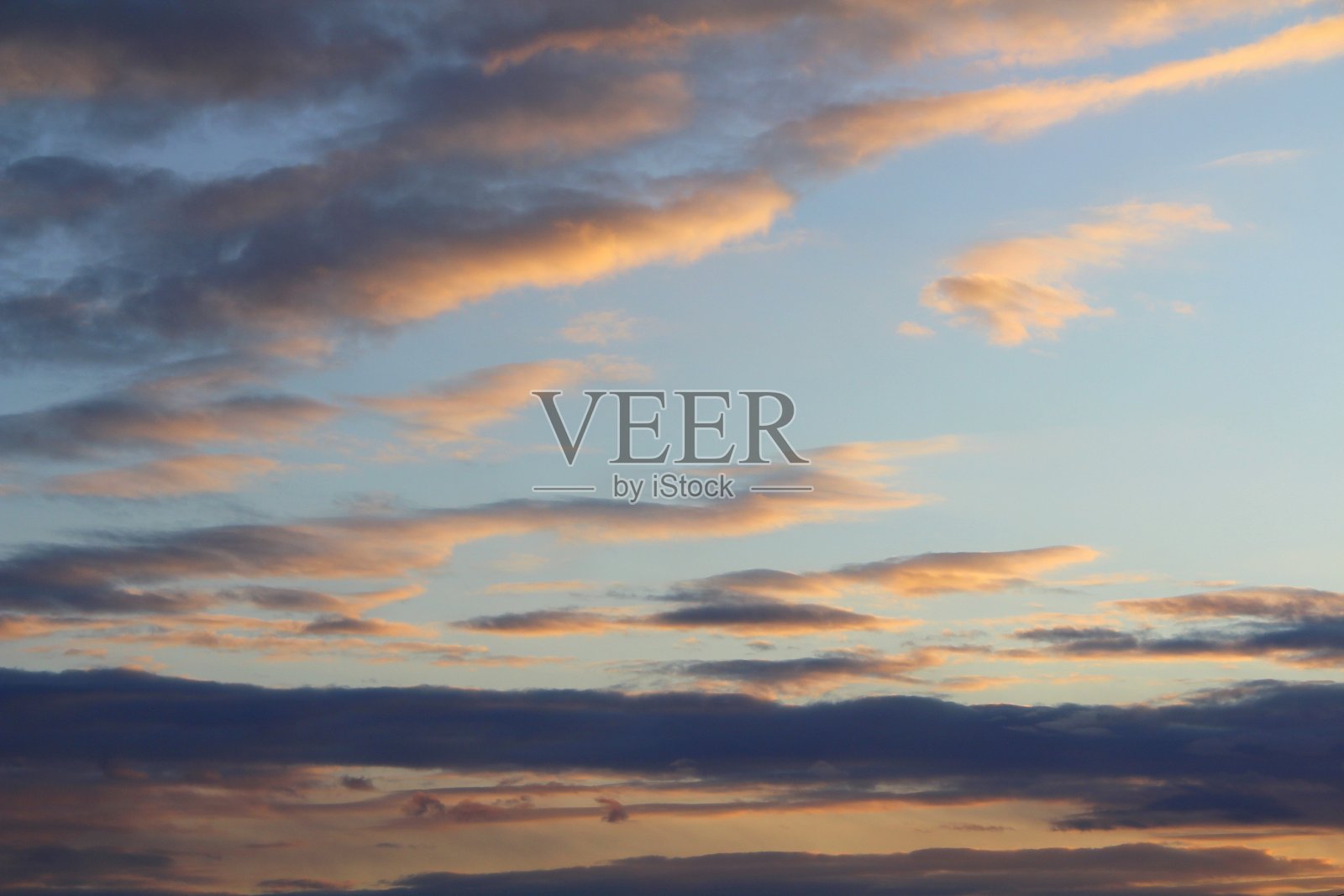 天空中的云被太阳的红光从下面照亮了。黄昏时的日落或日出景象照片摄影图片