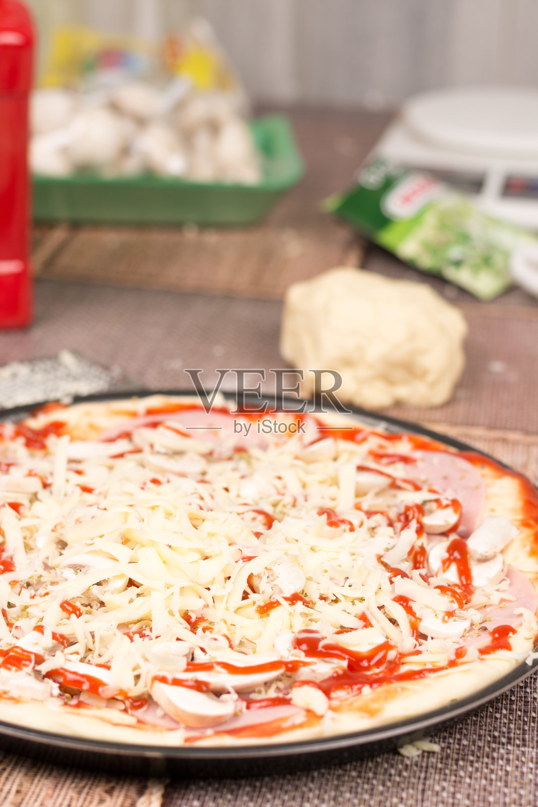 准备在烤箱中烘烤的生披萨照片摄影图片