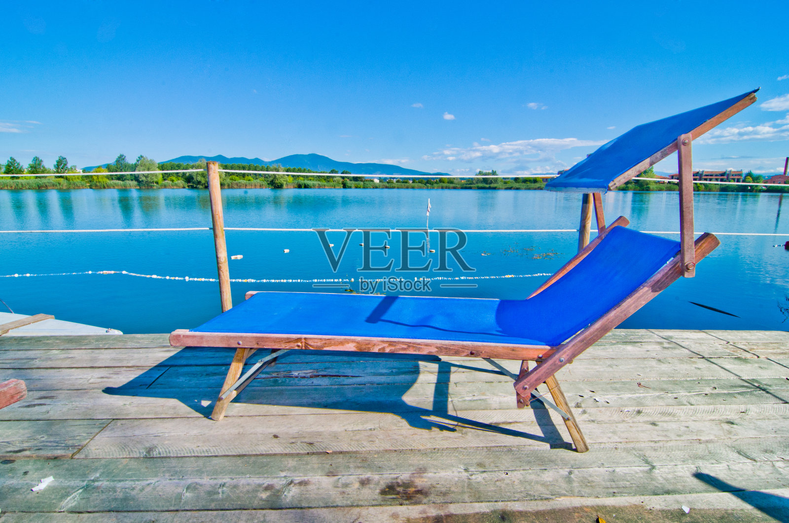 城市附近的湛蓝湖，有躺椅和游戏照片摄影图片